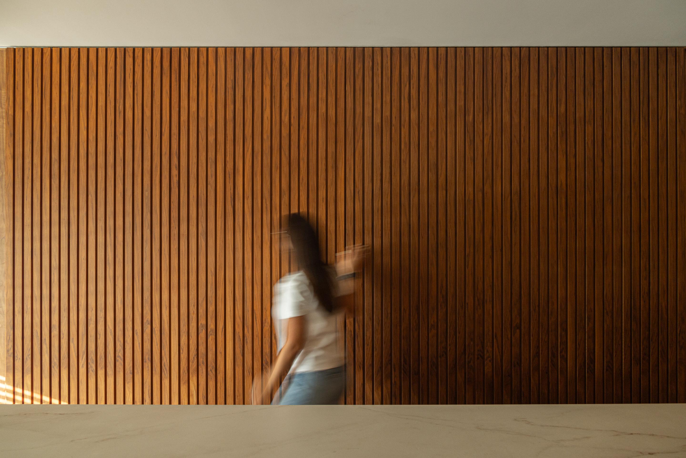 Sala de estar: Detalhe da porta de correr em ripas de madeira escura. — Casa do Engenho arquitetura silverline em Vila Nova de Gaia