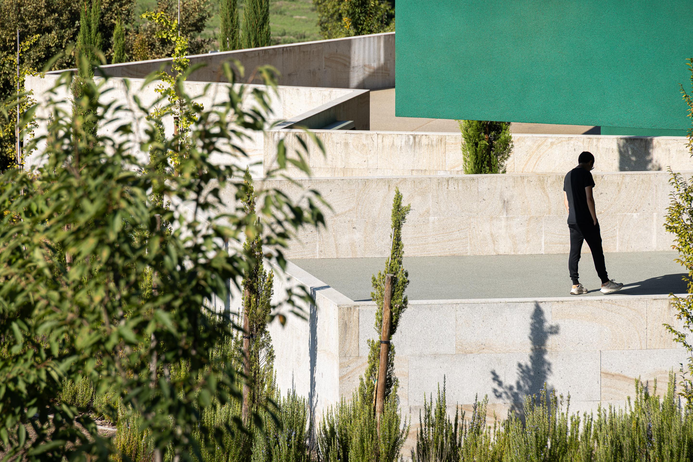 Exterior: Terraços em pedra com vista panorâmica, integrados no edifício verde. — Ponto C - Cultura e Criatividade arquitetura Galeria Gabinete em Penafiel