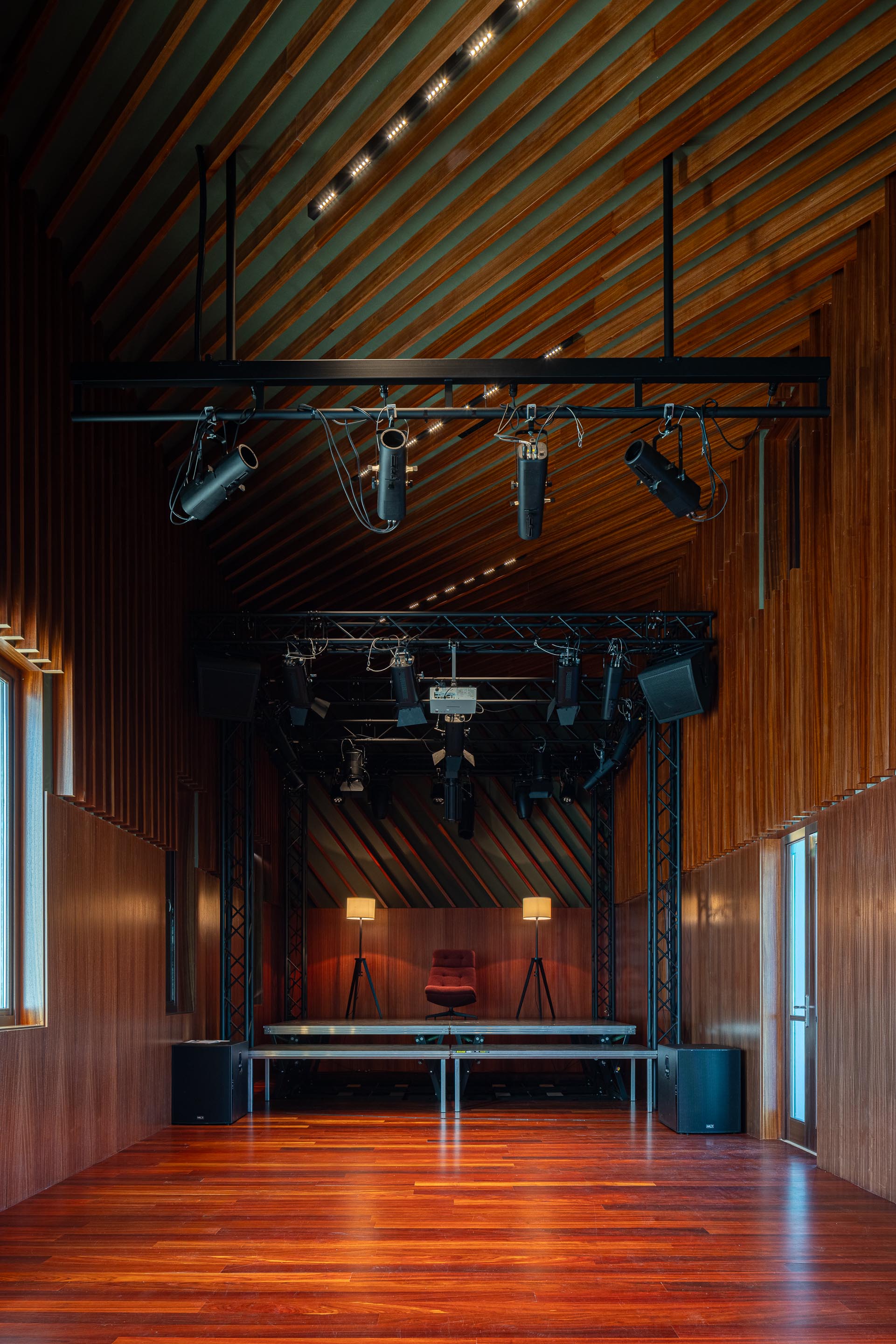 Palco: Espaço com iluminação cénica, paredes em madeira e pavimento em madeira escura. — Ponto C - Cultura e Criatividade arquitetura Galeria Gabinete em Penafiel