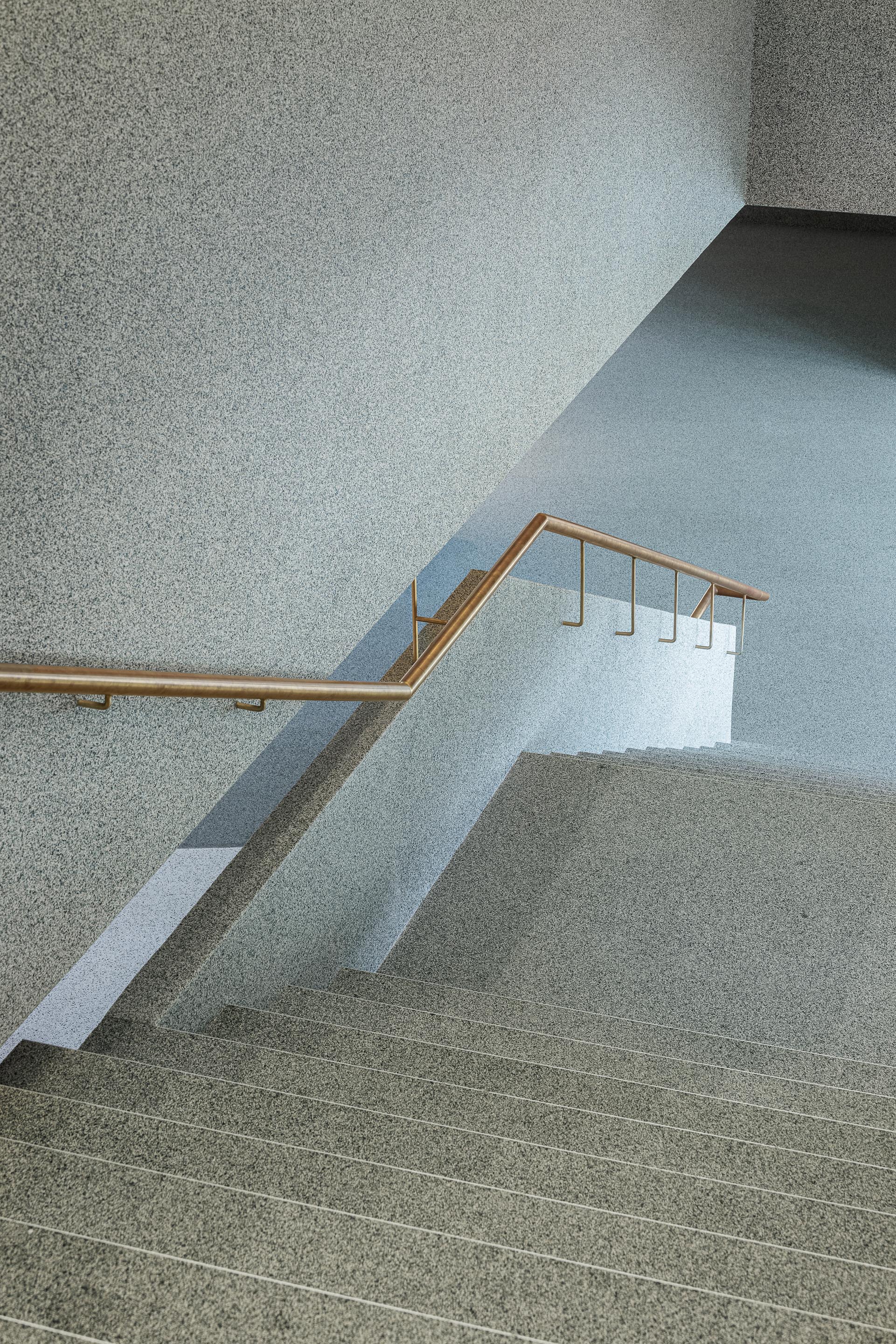 Escadas: Degraus em granito com corrimão em metal dourado e parede texturada. — Ponto C - Cultura e Criatividade arquitetura Galeria Gabinete em Penafiel