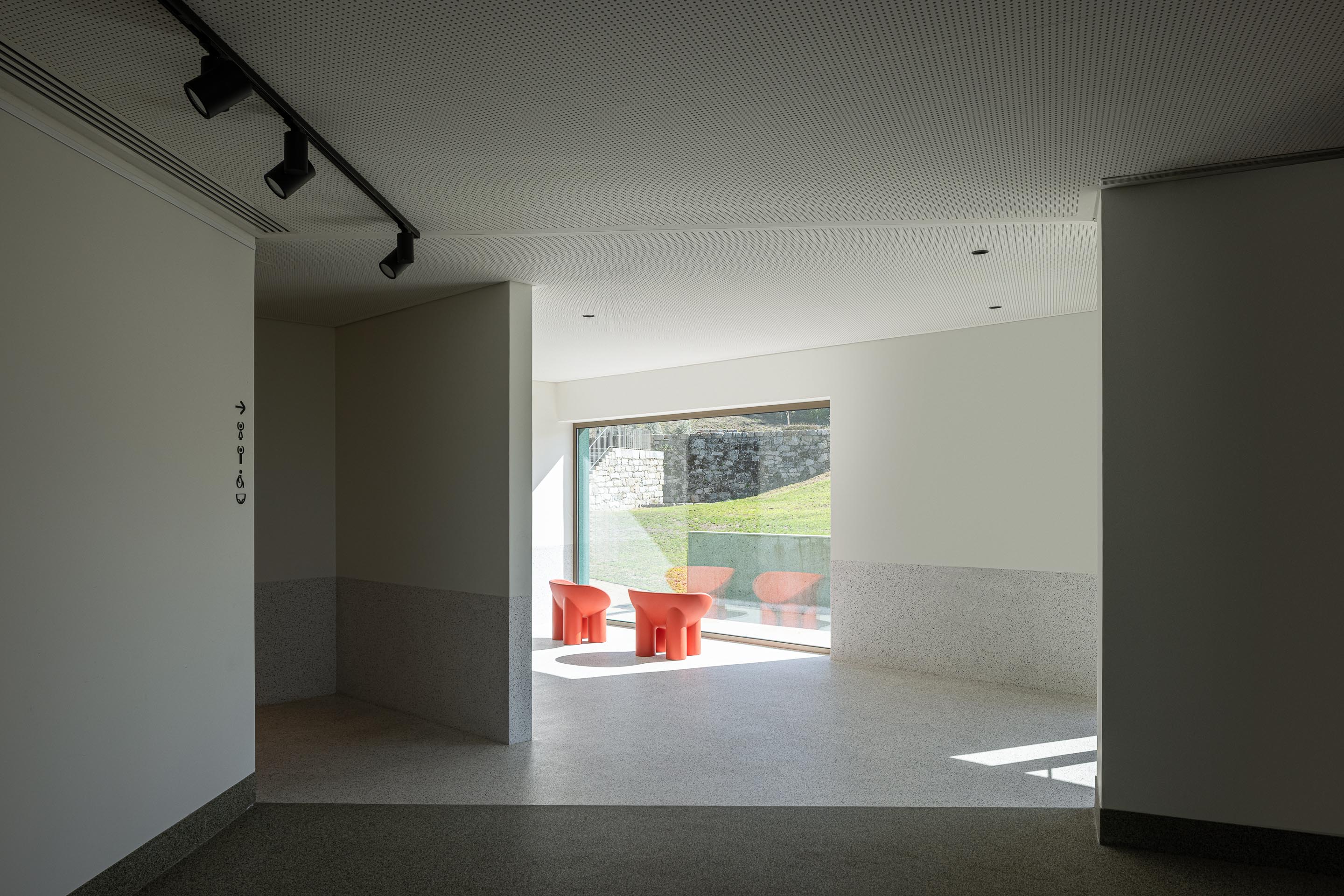 Espaço de estar: Cadeiras laranjas de design moderno e vista para o exterior. — Ponto C - Cultura e Criatividade arquitetura Galeria Gabinete em Penafiel