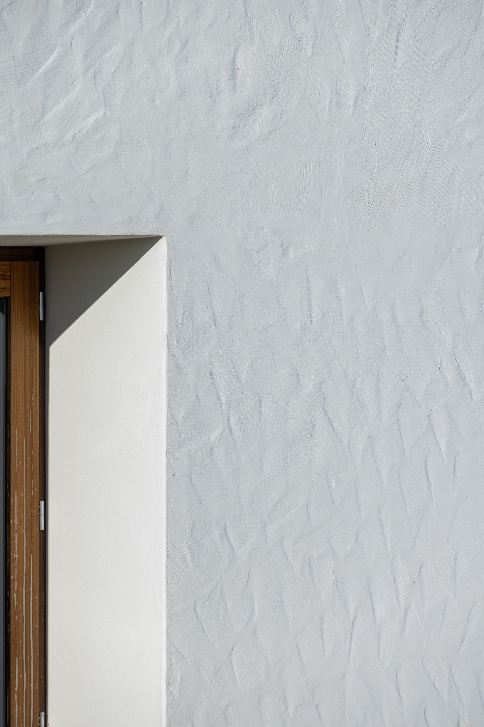 Detalhe: Textura da fachada branca com janela em madeira. — Ponto C - Cultura e Criatividade arquitetura Galeria Gabinete em Penafiel