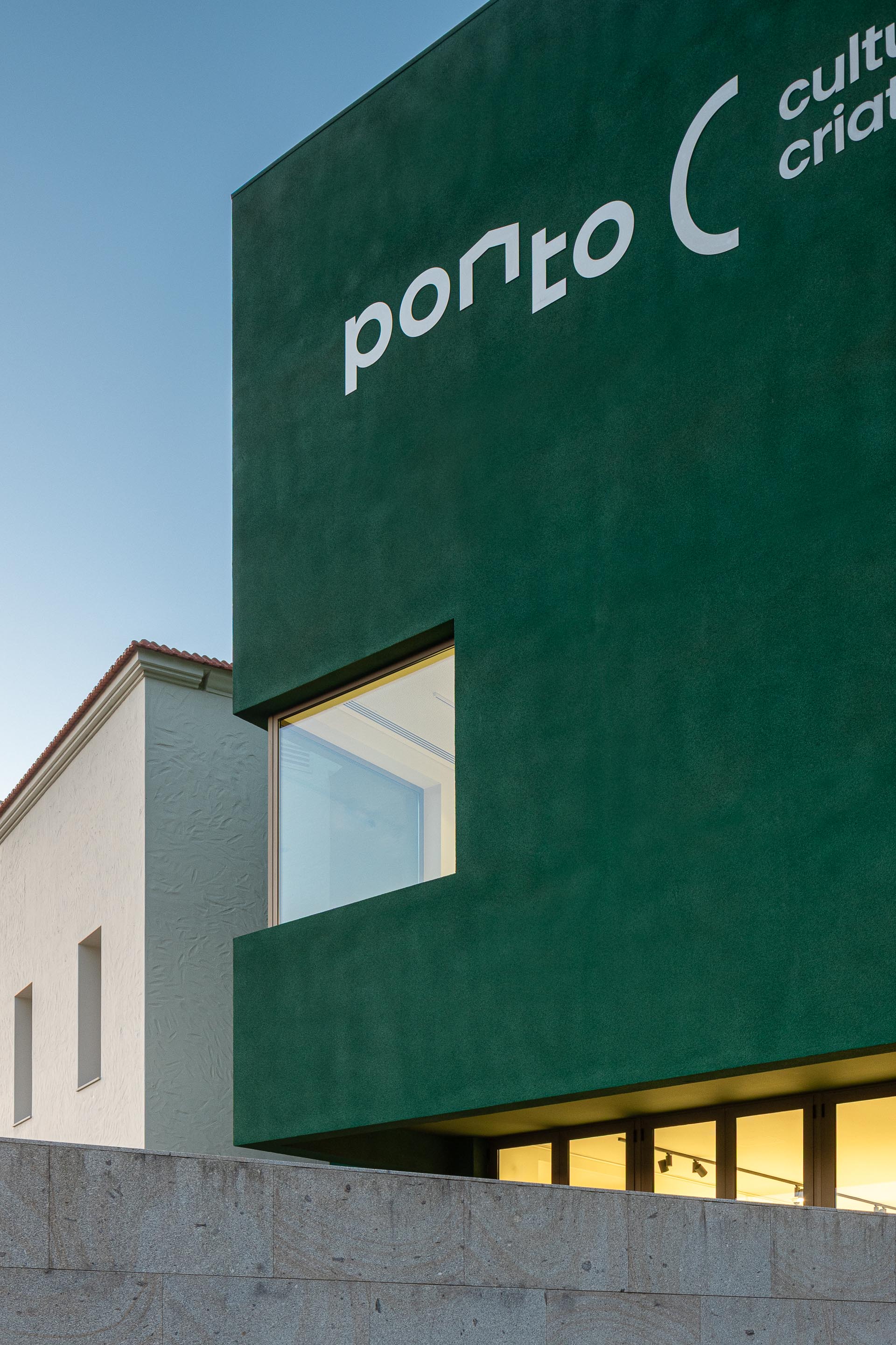 Fachada: Detalhe da fachada verde com o nome "Ponto C" e edifício branco ao lado. — Ponto C - Cultura e Criatividade arquitetura Galeria Gabinete em Penafiel