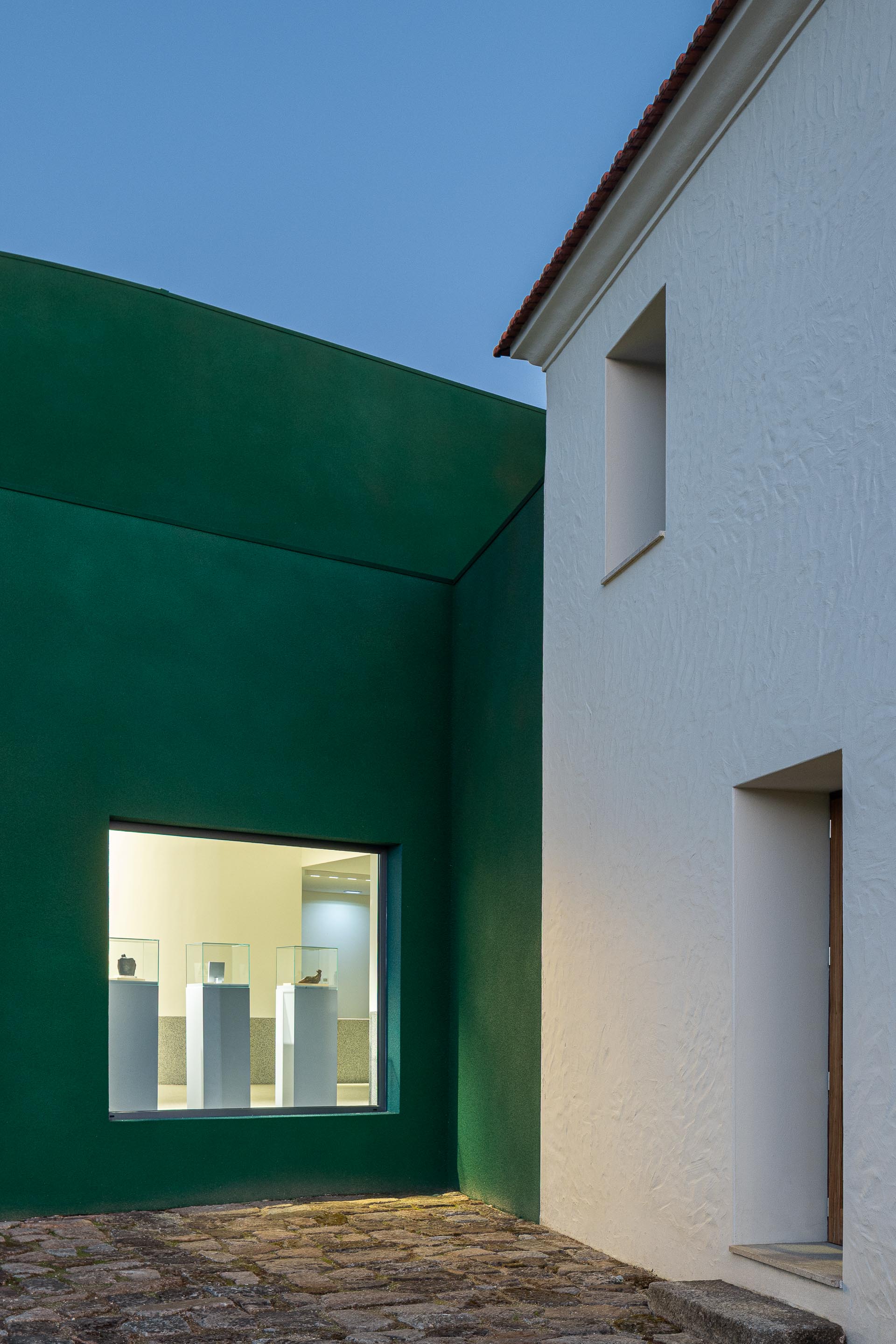 Exterior: Edifício branco com janela e edifício verde com janela para a galeria de arte. — Ponto C - Cultura e Criatividade arquitetura Galeria Gabinete em Penafiel