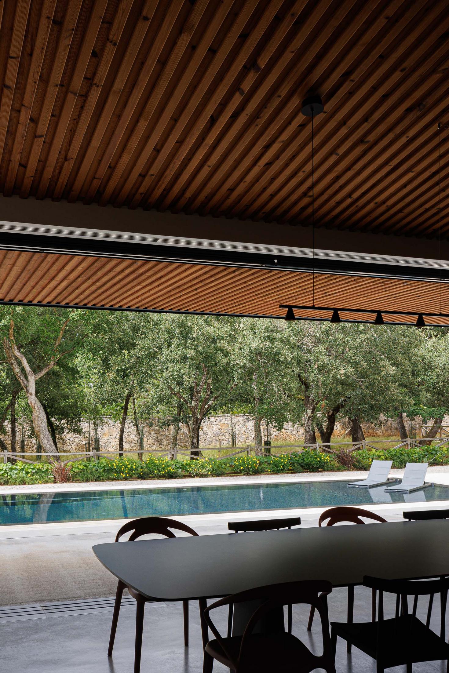 Cozinha/Sala de jantar: Vista da mesa de jantar para a piscina e jardim. — CC House – Quinta dos Carvalhos arquitetura Inception Architects Studio em Leiria