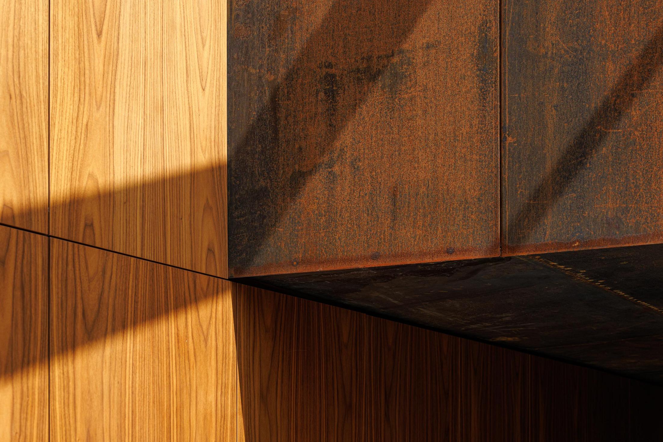 Detalhe: Encontro entre revestimento em madeira e aço corten, com jogo de luz e sombra. — Casa Corten arquitetura HPA Arquitetura e Investimentos em Celorico de Basto