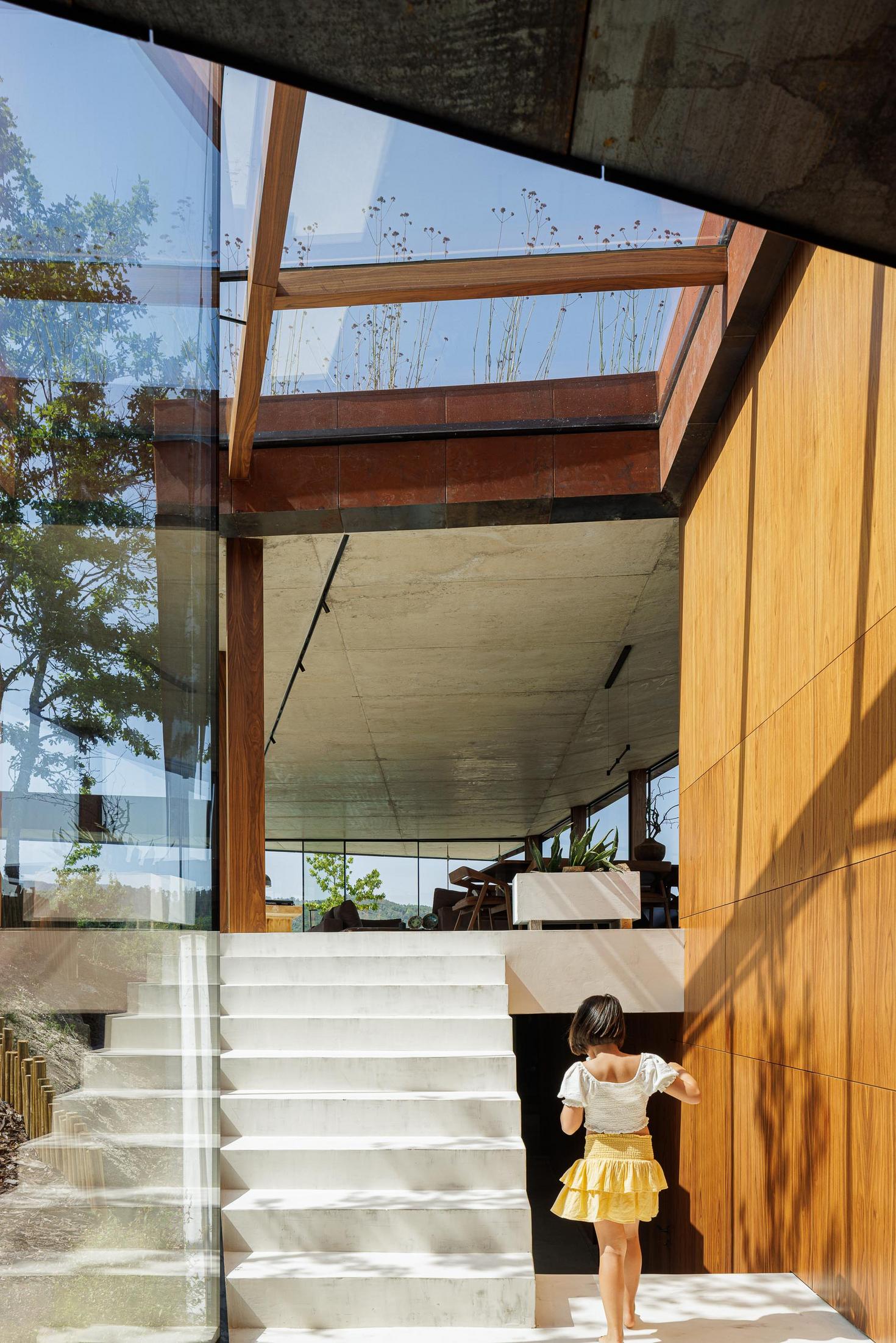 Escadas: Escadas exteriores com degraus brancos, paredes em madeira e claraboia no topo. — Casa Corten arquitetura HPA Arquitetura e Investimentos em Celorico de Basto