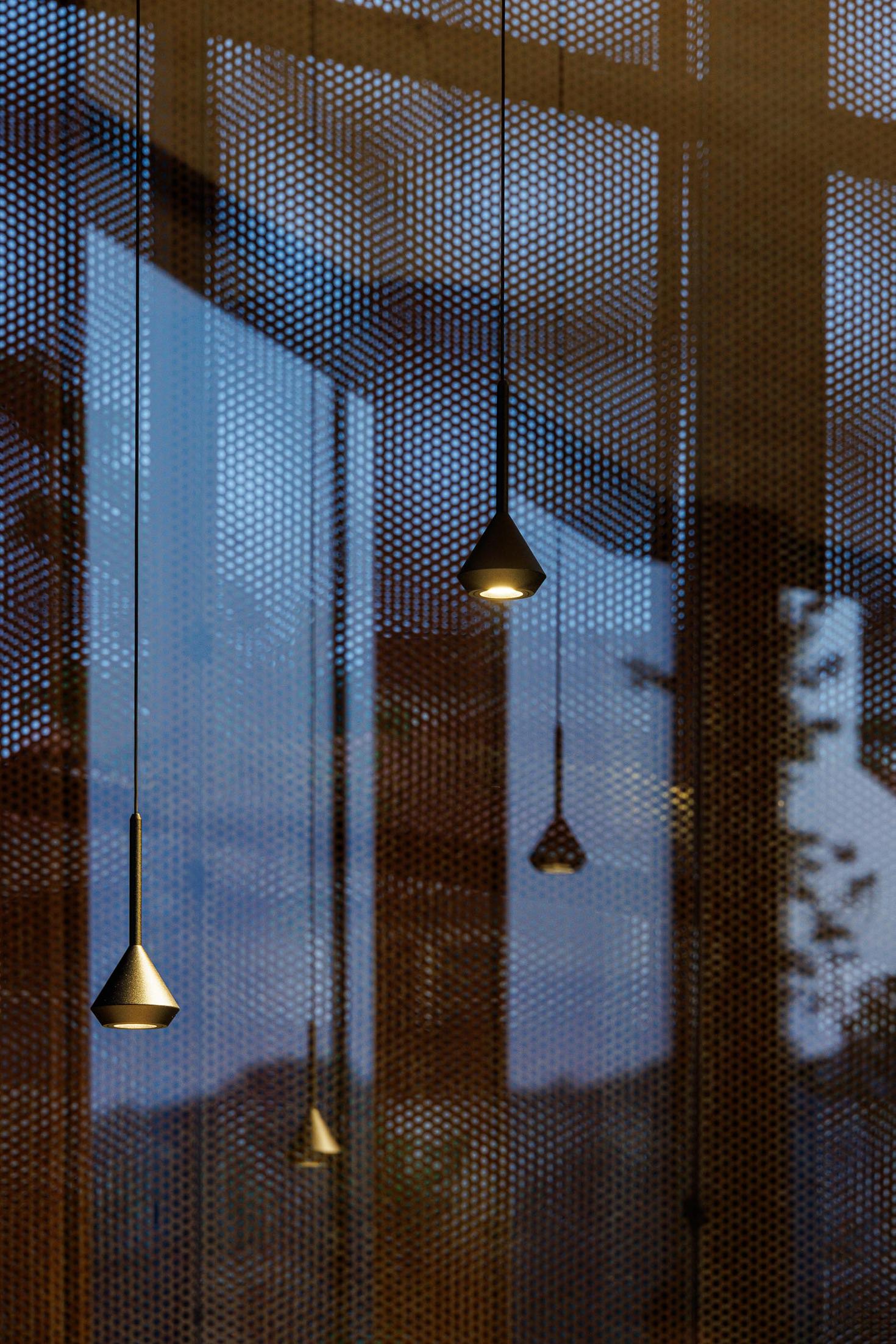 Exterior: Vista frontal da casa iluminada ao anoitecer, com fachada em aço corten e caminho de acesso. — Casa Corten arquitetura HPA Arquitetura e Investimentos em Celorico de Basto