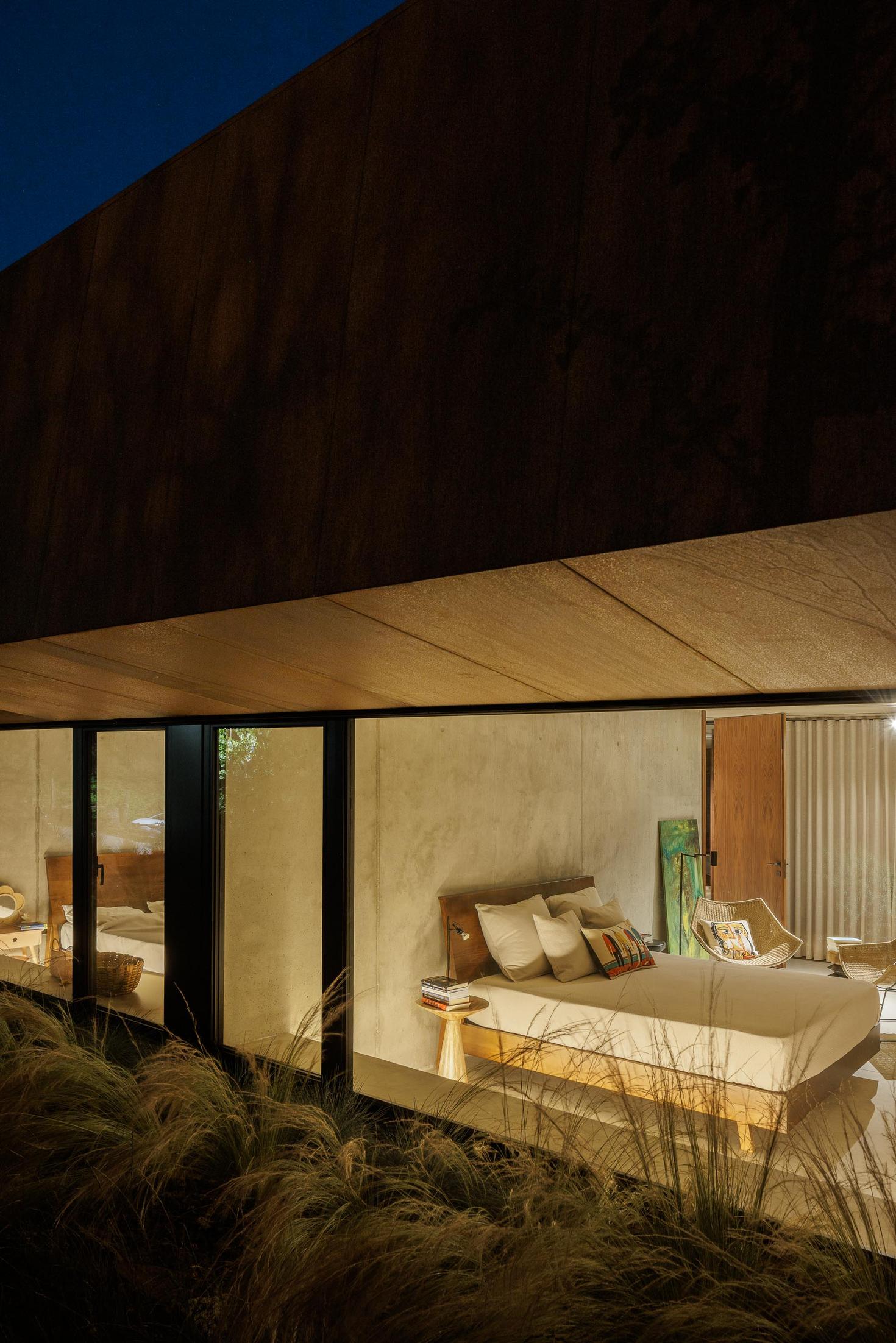 Exterior: Vista lateral da casa Corten, com caminho de acesso em lajes de pedra e vegetação envolvente. — Casa Corten arquitetura HPA Arquitetura e Investimentos em Celorico de Basto