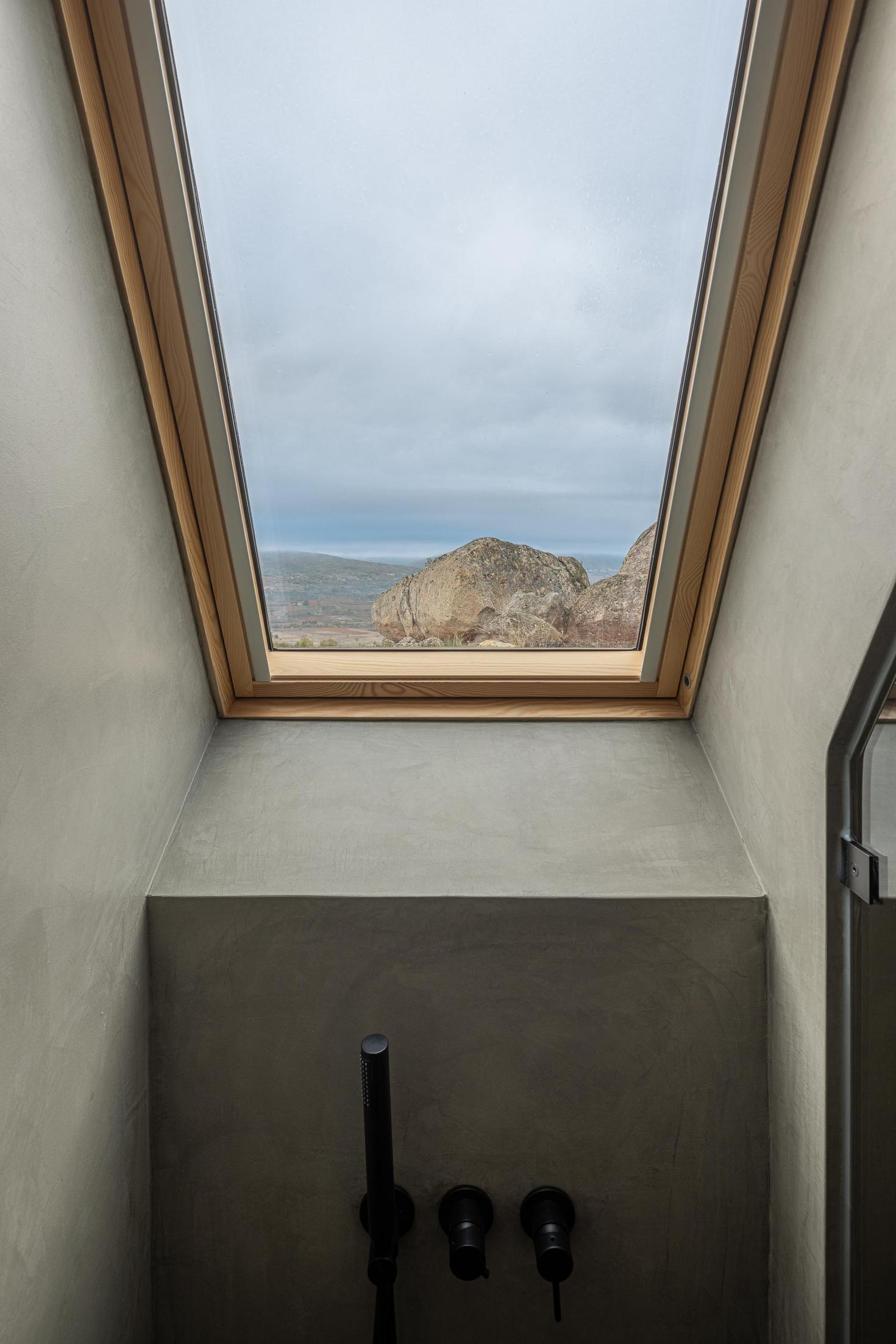Casa de banho com duche e claraboia. Revestimento cinzento nas paredes. — Abrigos de Montanha arquitetura Filipe Pina Arquitectura em Belmonte
