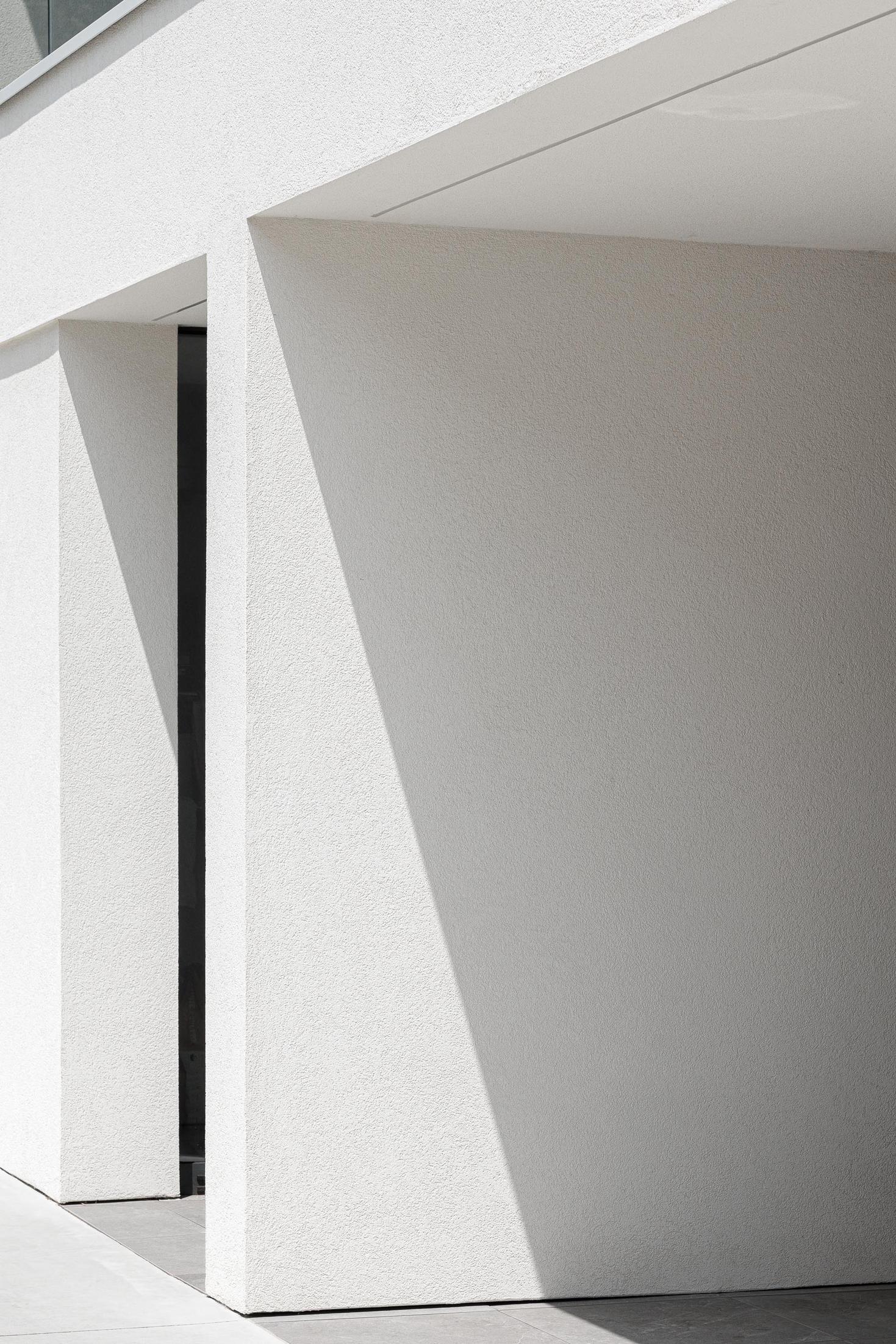 Exterior: Detalhe da fachada branca com porta envidraçada. — Casa dos Sobreiros II arquitetura Urbanpolis em Póvoa de Varzim
