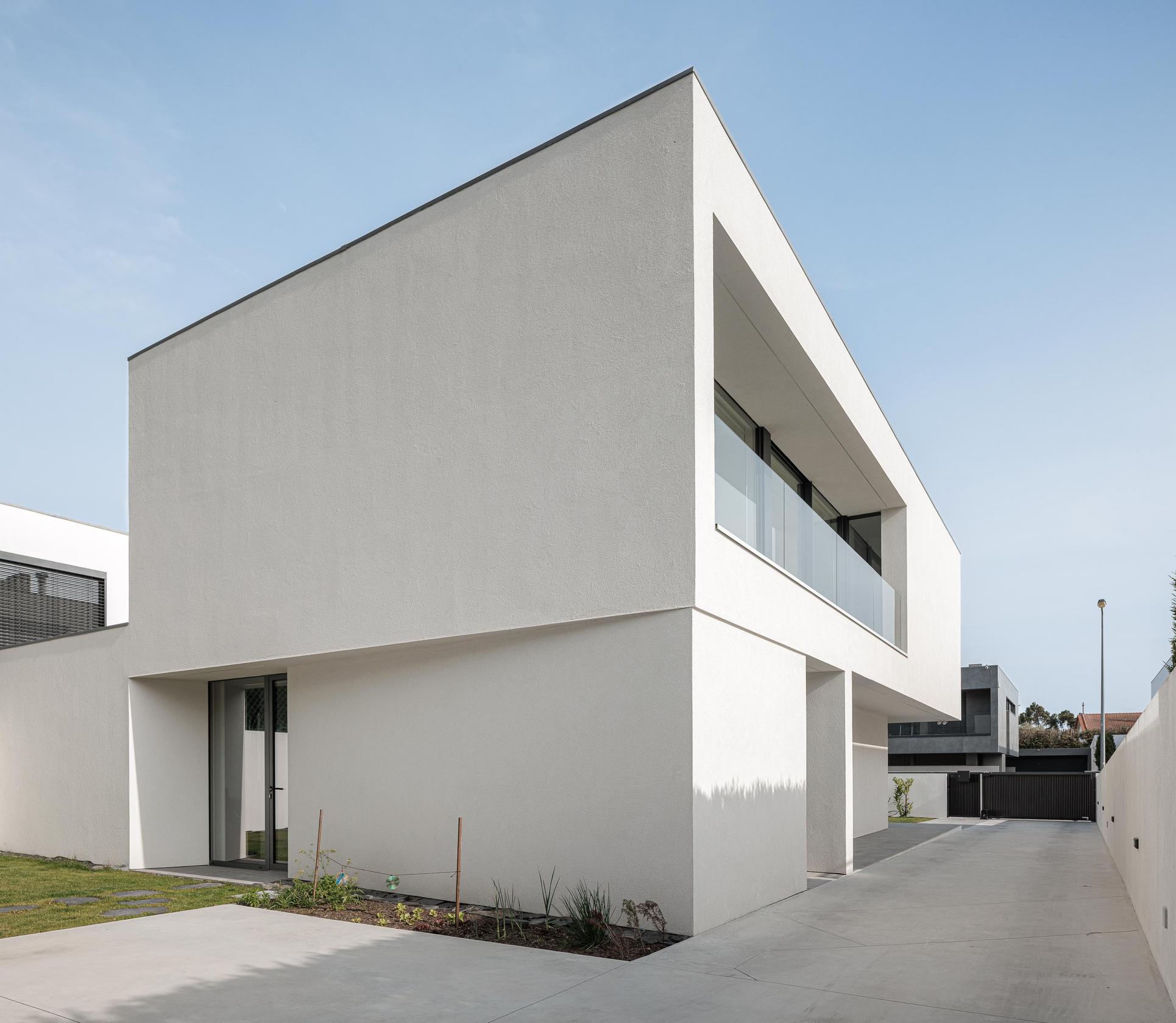 Exterior: Moradia branca minimalista com jardim e garagem. — Casa dos Sobreiros II arquitetura Urbanpolis em Póvoa de Varzim
