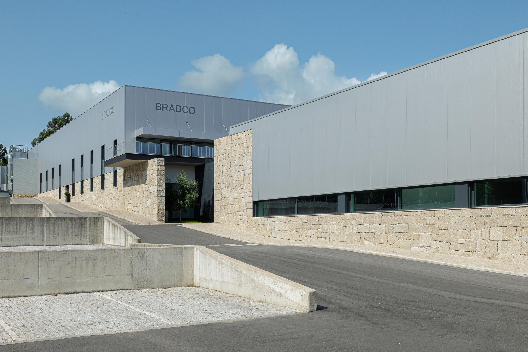 Entrada principal: Edifício com nome "BRADCO" e escadaria exterior em pedra. — Bradco II arquitetura Em Paralelo em Castelo de Paiva
