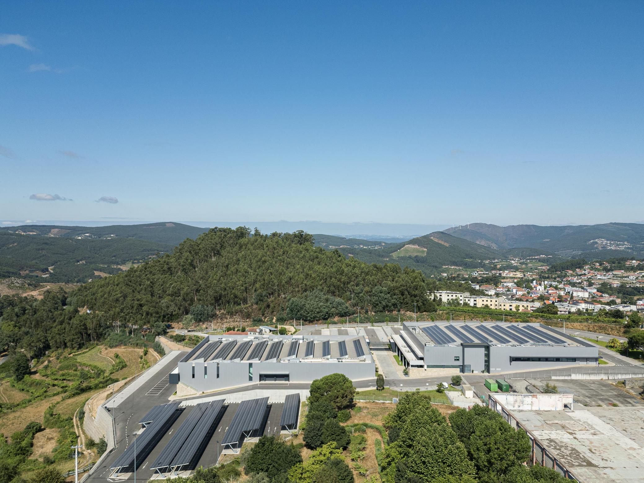 Vista aérea: Complexo industrial com painéis solares e paisagem montanhosa. — Bradco II arquitetura Em Paralelo em Castelo de Paiva