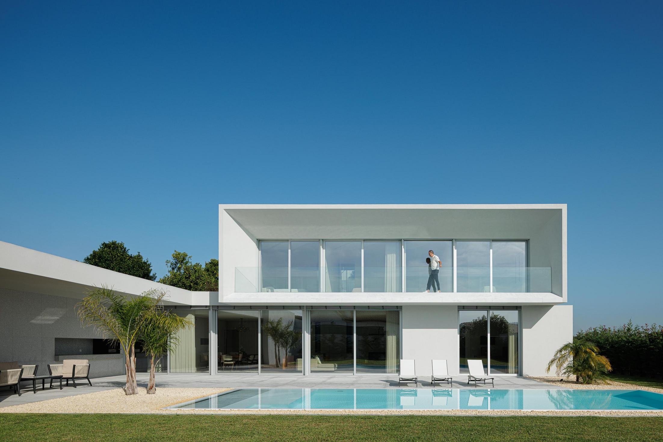 Exterior: Fachada posterior da casa com piscina, zona de estar e varanda no piso superior. — Casa Branca Minimalista arquitetura Arquitetura501 em Braga