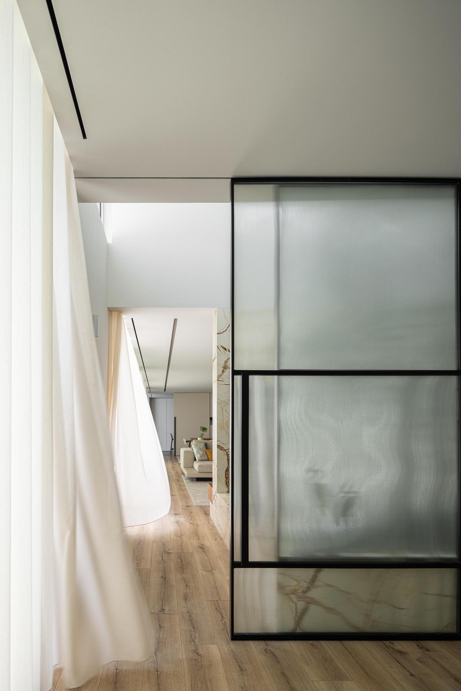 Corredor: Porta de vidro texturizado com caixilharia preta, cortina branca e vista para a sala. — Casa Branca Minimalista arquitetura Arquitetura501 em Braga