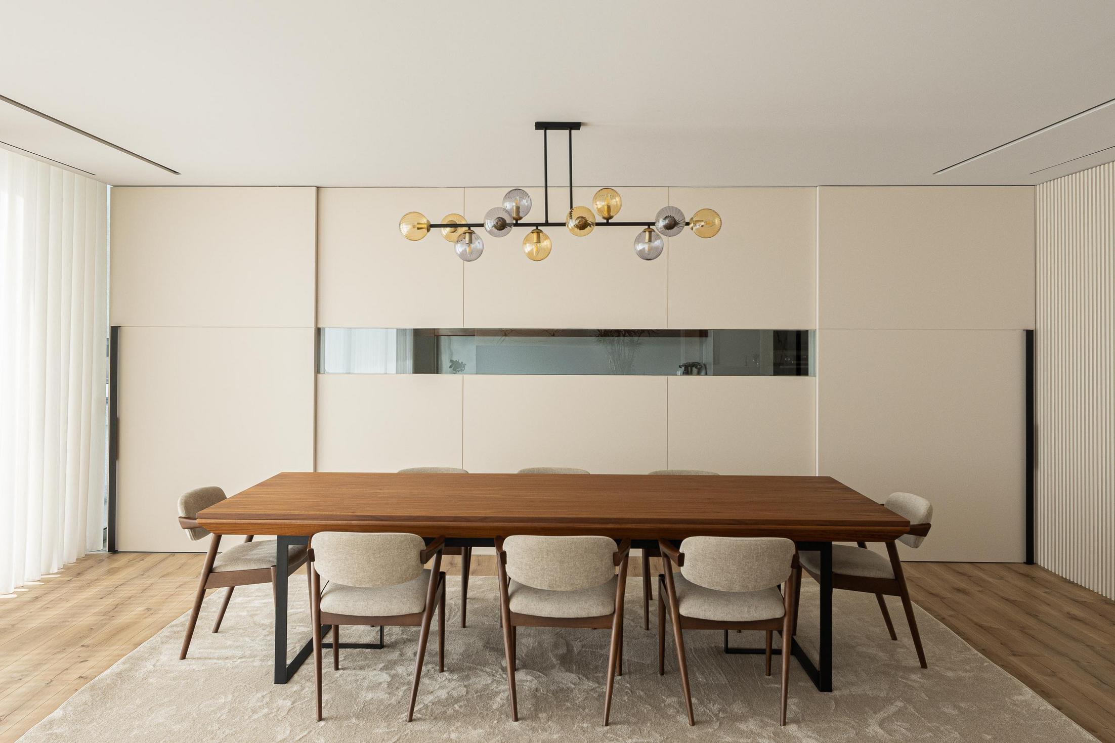 Sala de jantar: Mesa de jantar em madeira, cadeiras estofadas e candeeiro suspenso. — Casa Branca Minimalista arquitetura Arquitetura501 em Braga