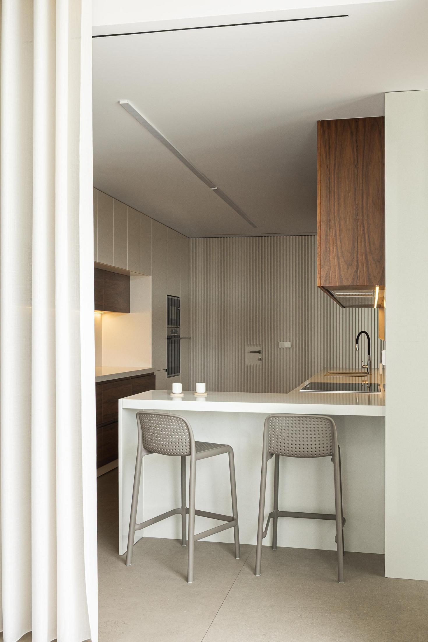 Corredor superior: Pessoa a olhar para o jardim interior através da janela. — Casa Branca Minimalista arquitetura Arquitetura501 em Braga