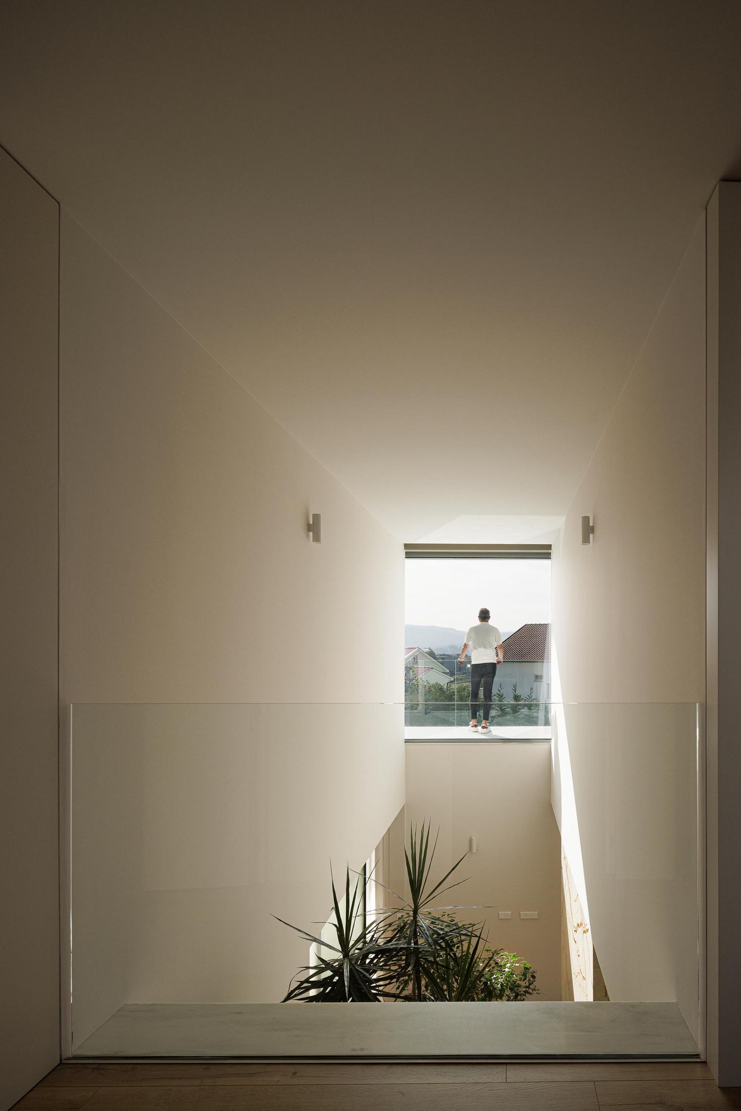Escadas: Escadas em mármore com corrimão preto e revestimento em madeira. — Casa Branca Minimalista arquitetura Arquitetura501 em Braga