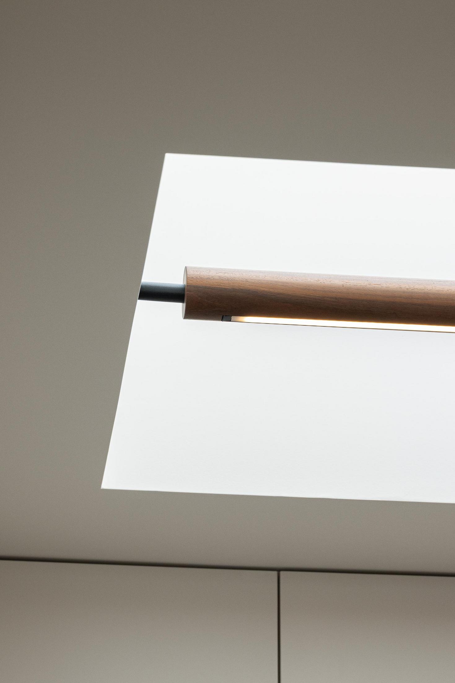 Detalhe: Candeeiro tubular de madeira sob claraboia branca. — Casa Branca Minimalista arquitetura Arquitetura501 em Braga