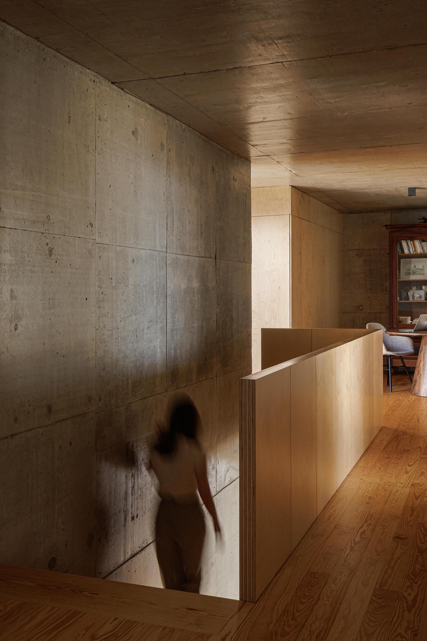 Escadas: Corredor com escadas em madeira e parede em betão. Iluminação suave. — Casa da Rocha Quebrada arquitetura SO Arquitetura & Design em São Miguel