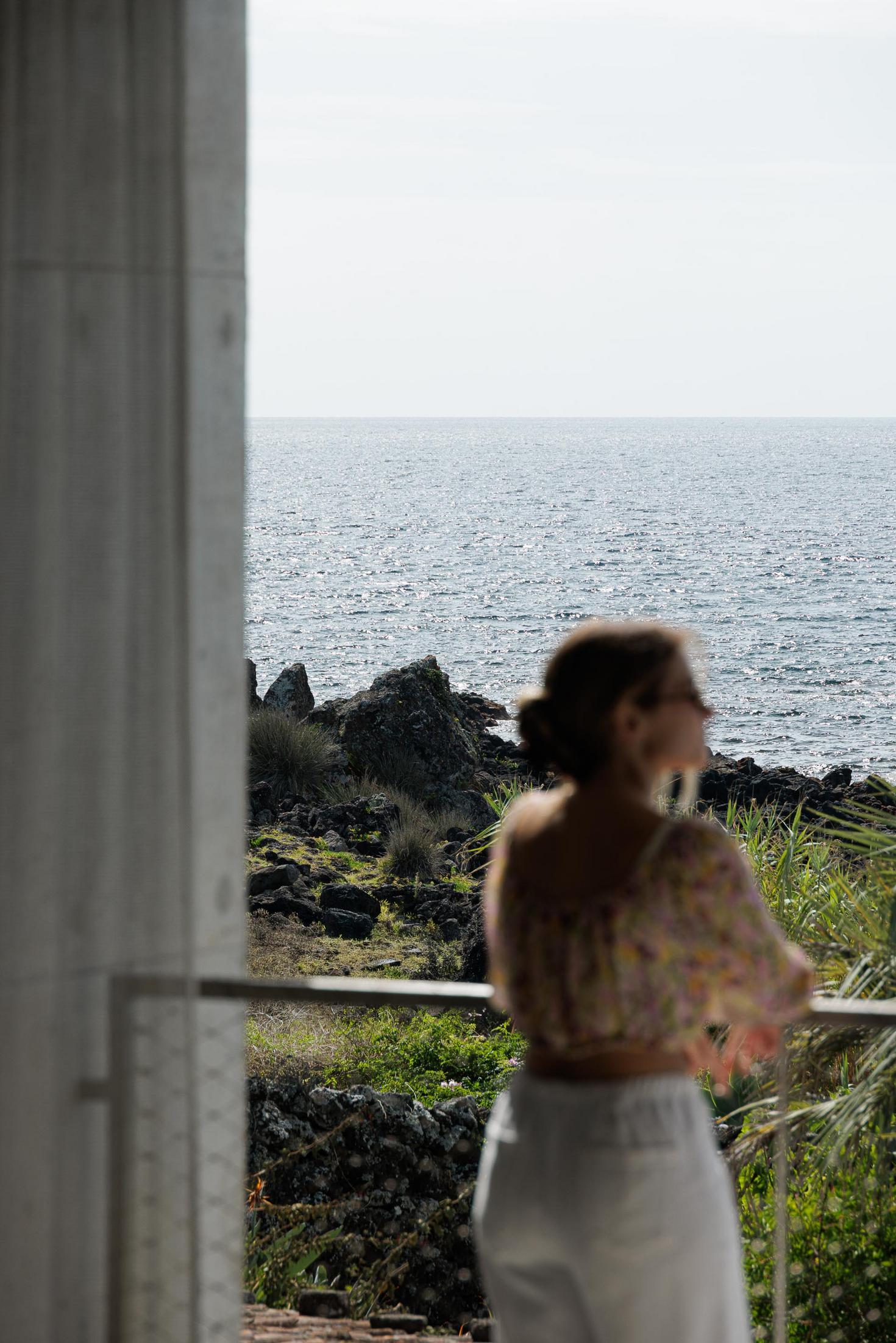 Varanda: Vista para o mar e vegetação. Guarda-corpo metálico e estrutura em betão. — Casa da Rocha Quebrada arquitetura SO Arquitetura & Design em São Miguel