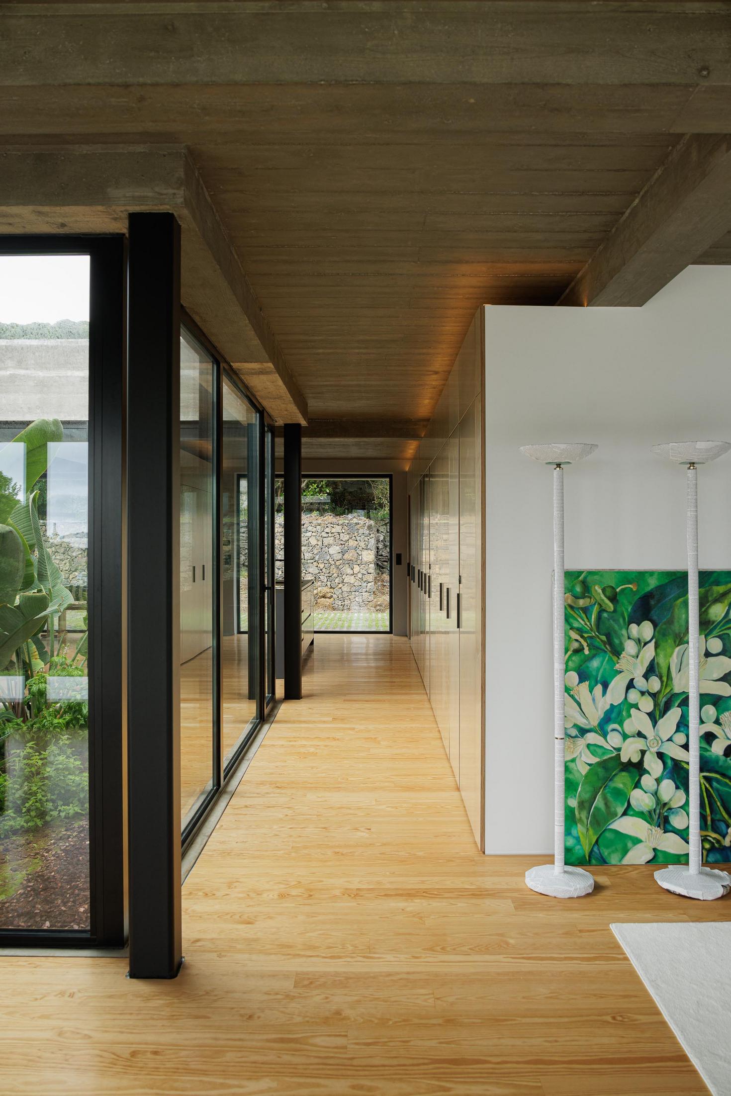Corredor: Armários em contraplacado, pavimento em madeira e candeeiros de pé com pintura floral. — Casa CR arquitetura SO Arquitetura & Design em São Miguel