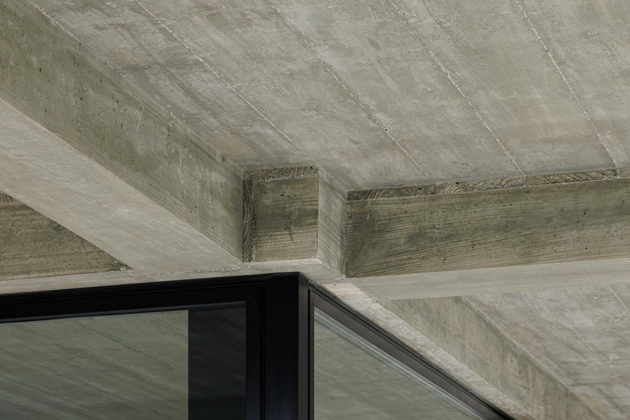 Detalhe: Teto em betão aparente com vigas e caixilharia preta das janelas. — Casa CR arquitetura SO Arquitetura & Design em São Miguel