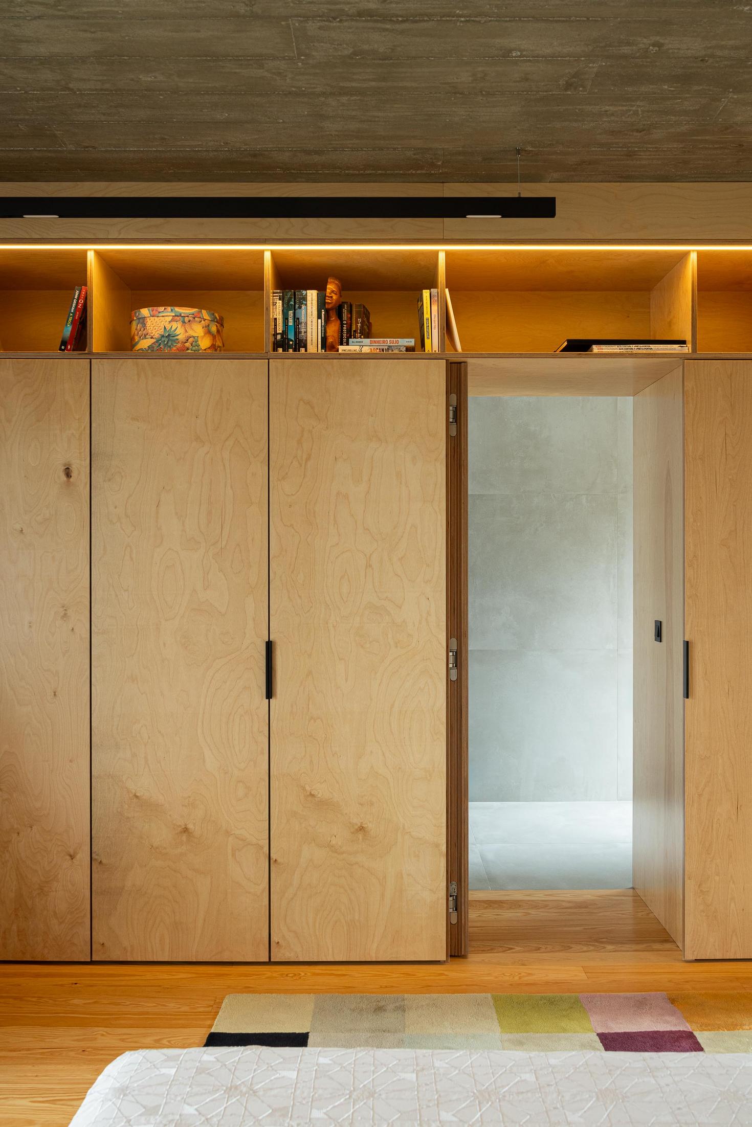 Quarto: Roupeiro em contraplacado com prateleiras e porta para casa de banho. Alcatifa geométrica. — Casa CR arquitetura SO Arquitetura & Design em São Miguel