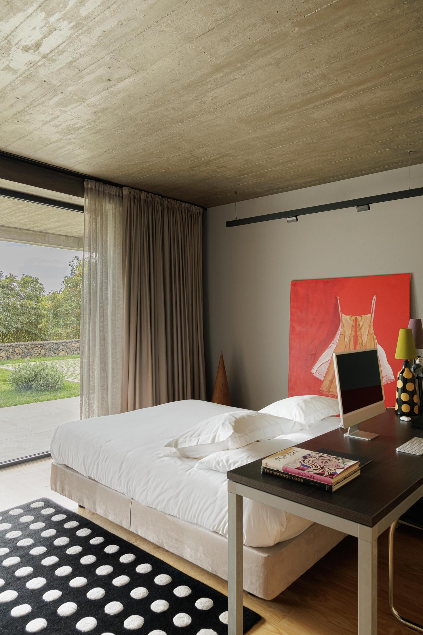 Quarto: Cama branca, secretária com computador e alcatifa com padrão de bolas. — Casa CR arquitetura SO Arquitetura & Design em São Miguel