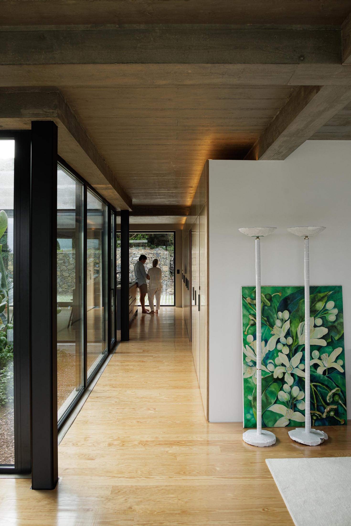 Corredor: Armários em contraplacado, pavimento em madeira e candeeiros de pé com pintura floral. — Casa CR arquitetura SO Arquitetura & Design em São Miguel