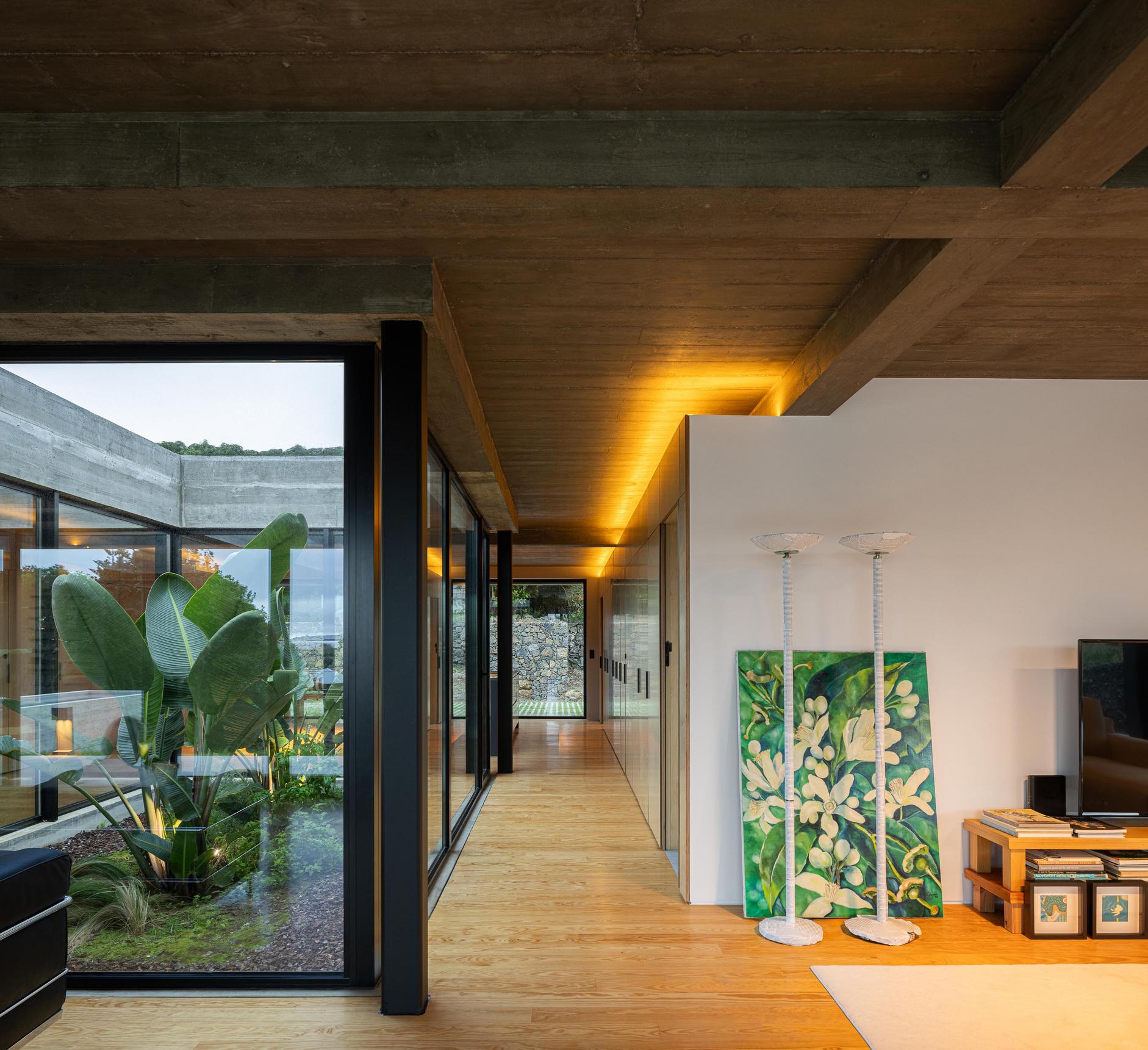 Sala de estar: Grandes janelas, armários em contraplacado e candeeiros de pé com pintura floral. — Casa CR arquitetura SO Arquitetura & Design em São Miguel