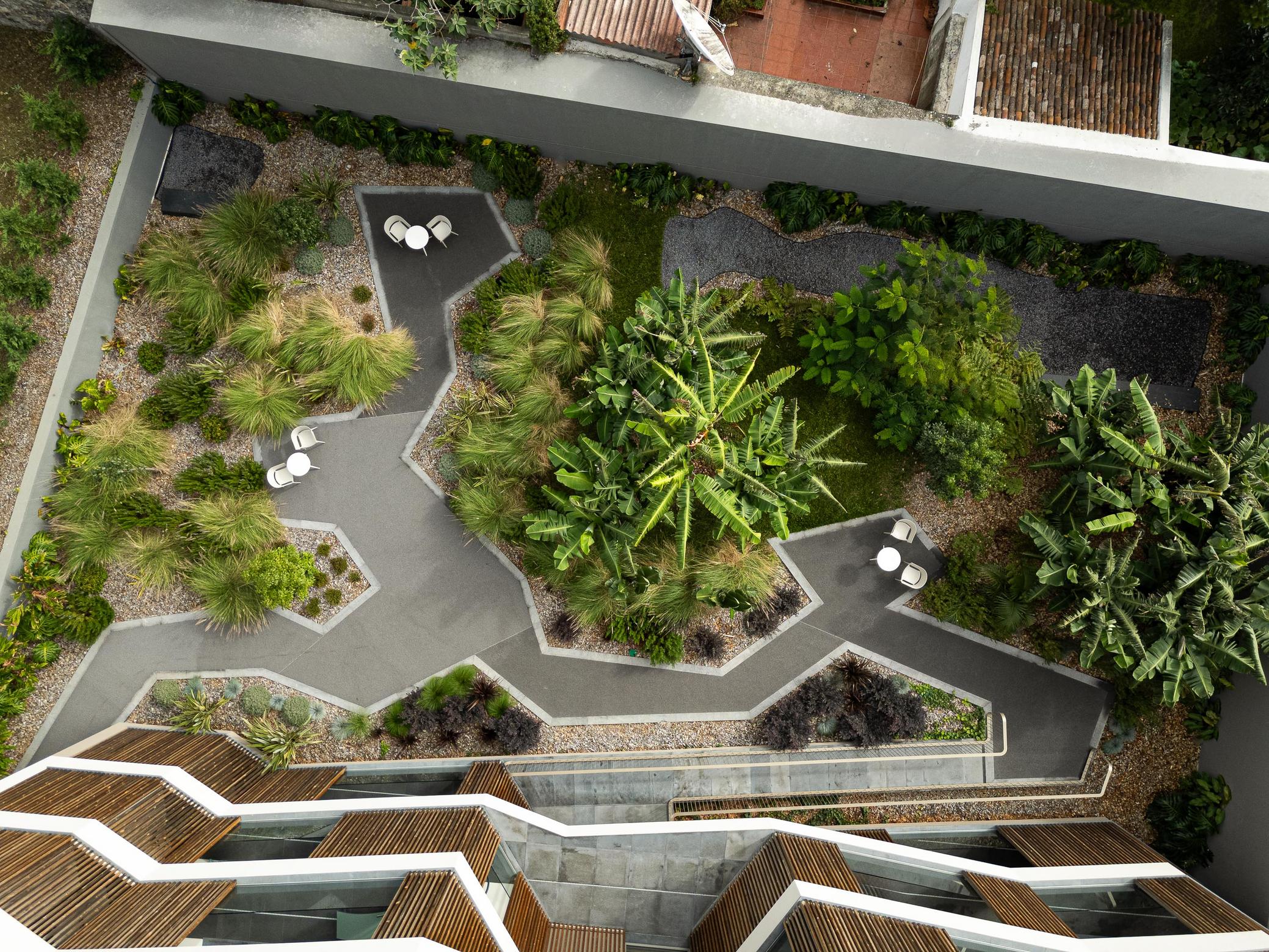 Jardim: Vista aérea do jardim interior com caminhos em agregado e áreas de estar. — ERNESTO DO CANTO - condomínio arquitetura BOX arquitectos em Ponta Delgada