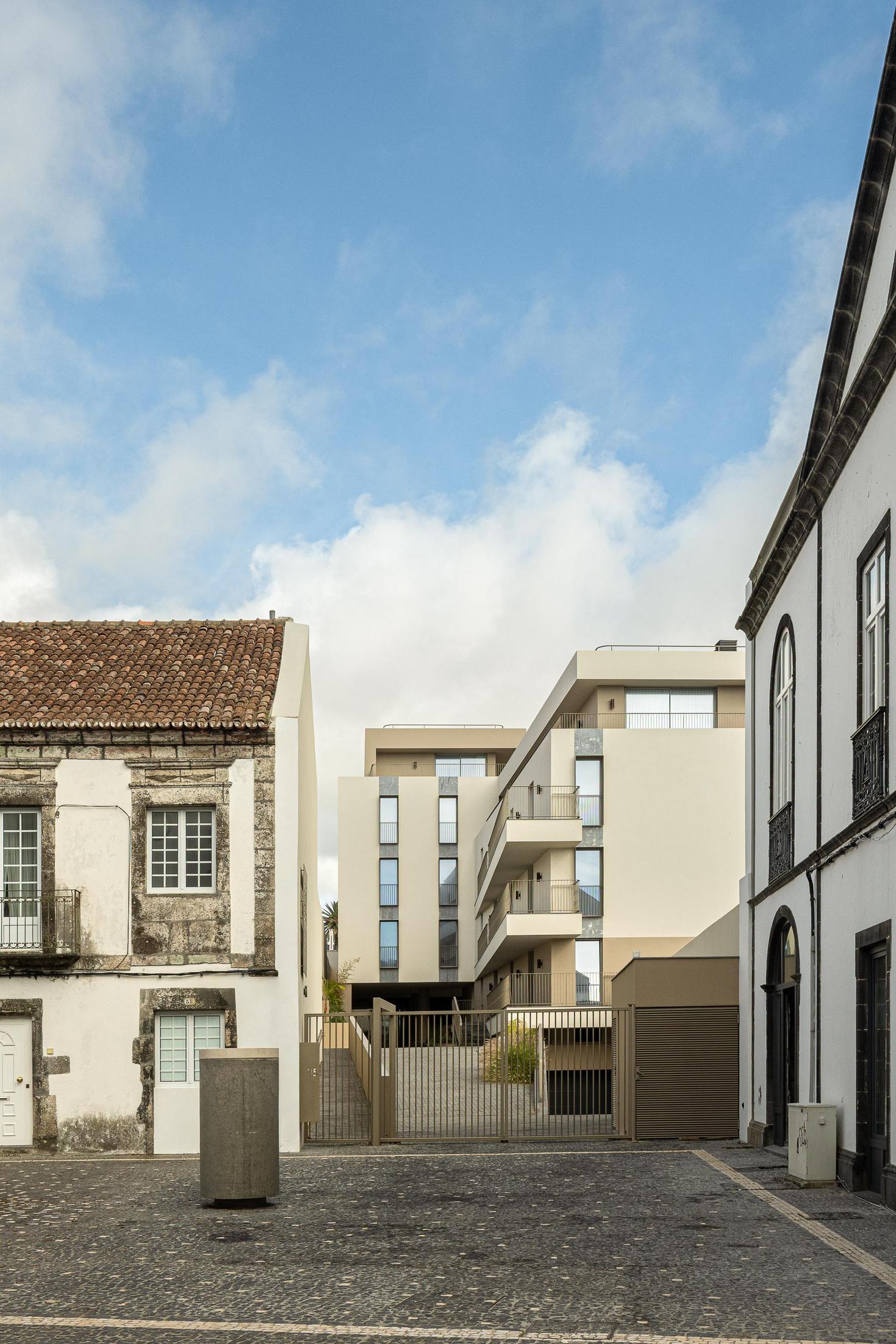 Rua: Edifício moderno integrado na malha urbana histórica, com ruas em calçada. — ERNESTO DO CANTO - condomínio arquitetura BOX arquitectos em Ponta Delgada