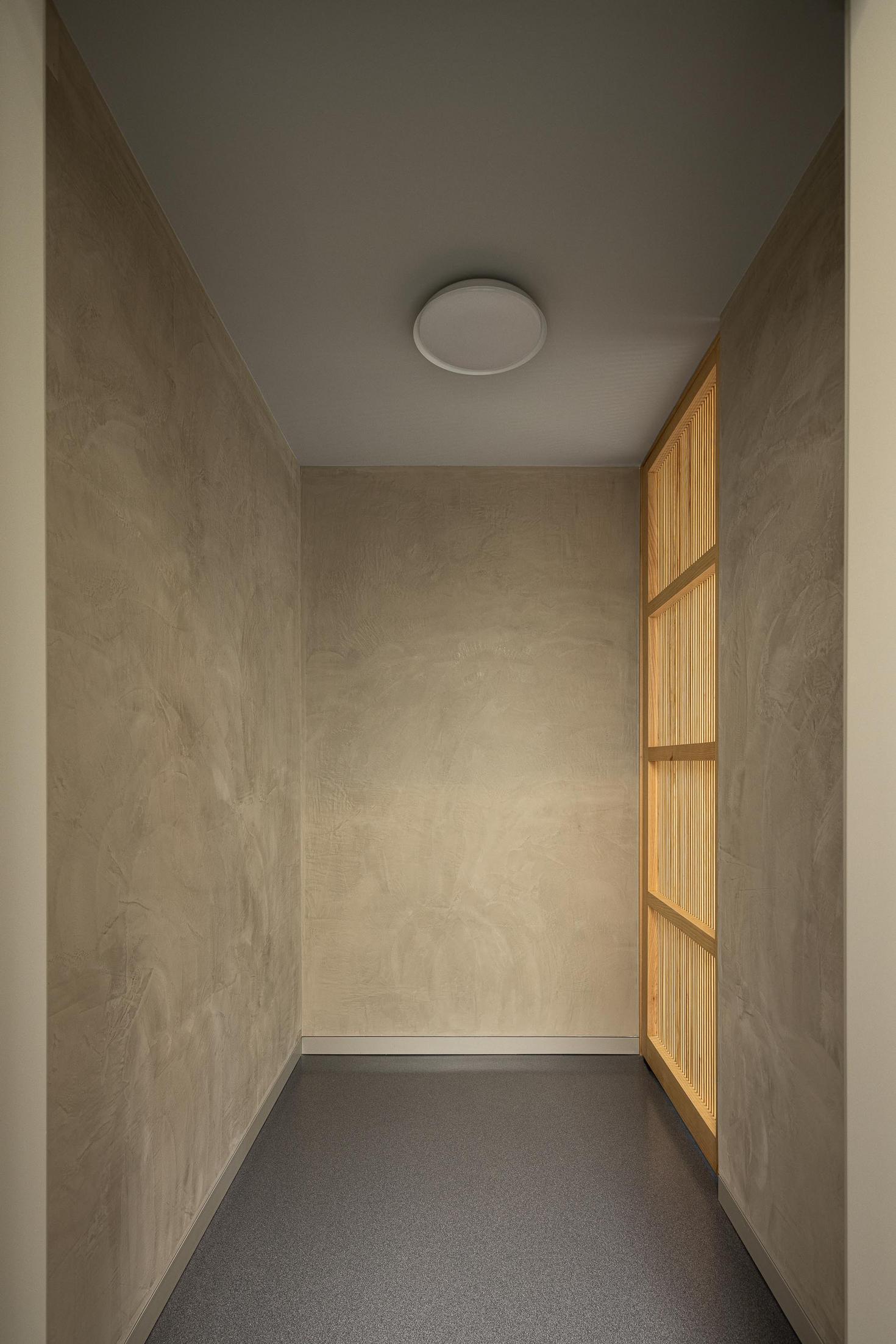 Hall de entrada: Pequeno espaço com ripas de madeira e pavimento escuro. — ERNESTO DO CANTO - condomínio arquitetura BOX arquitectos em Ponta Delgada