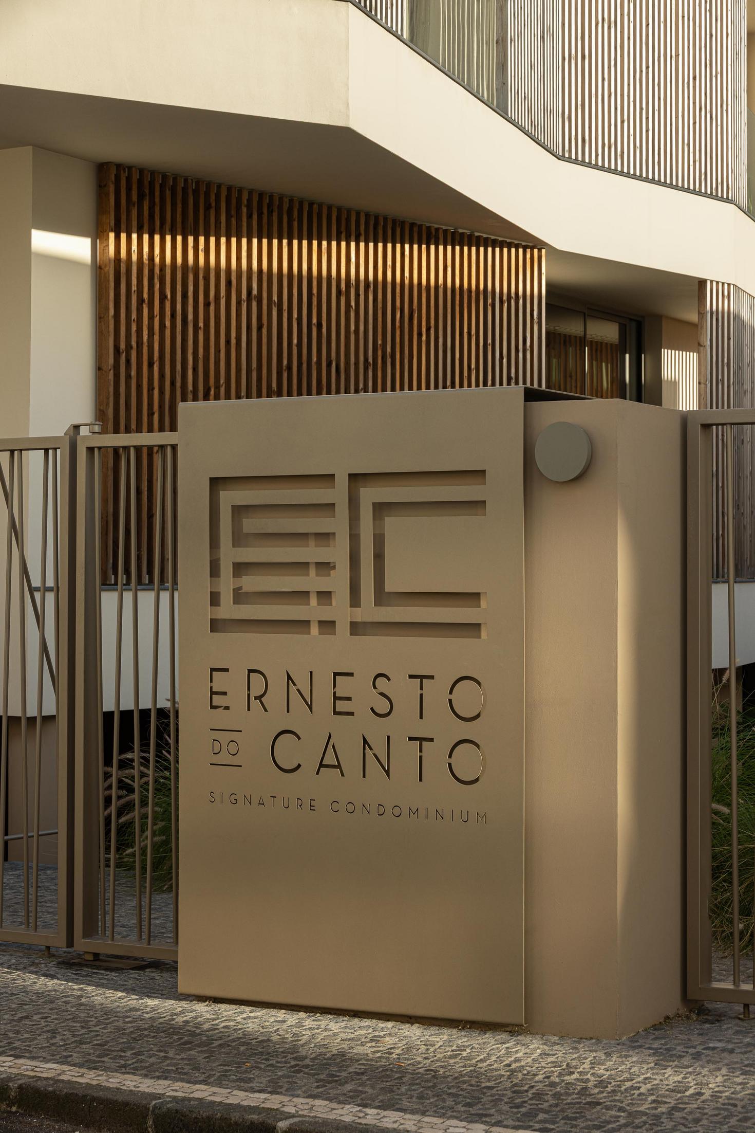 Entrada: Placa com o nome do condomínio "Ernesto do Canto" e grade de acesso. — ERNESTO DO CANTO - condomínio arquitetura BOX arquitectos em Ponta Delgada