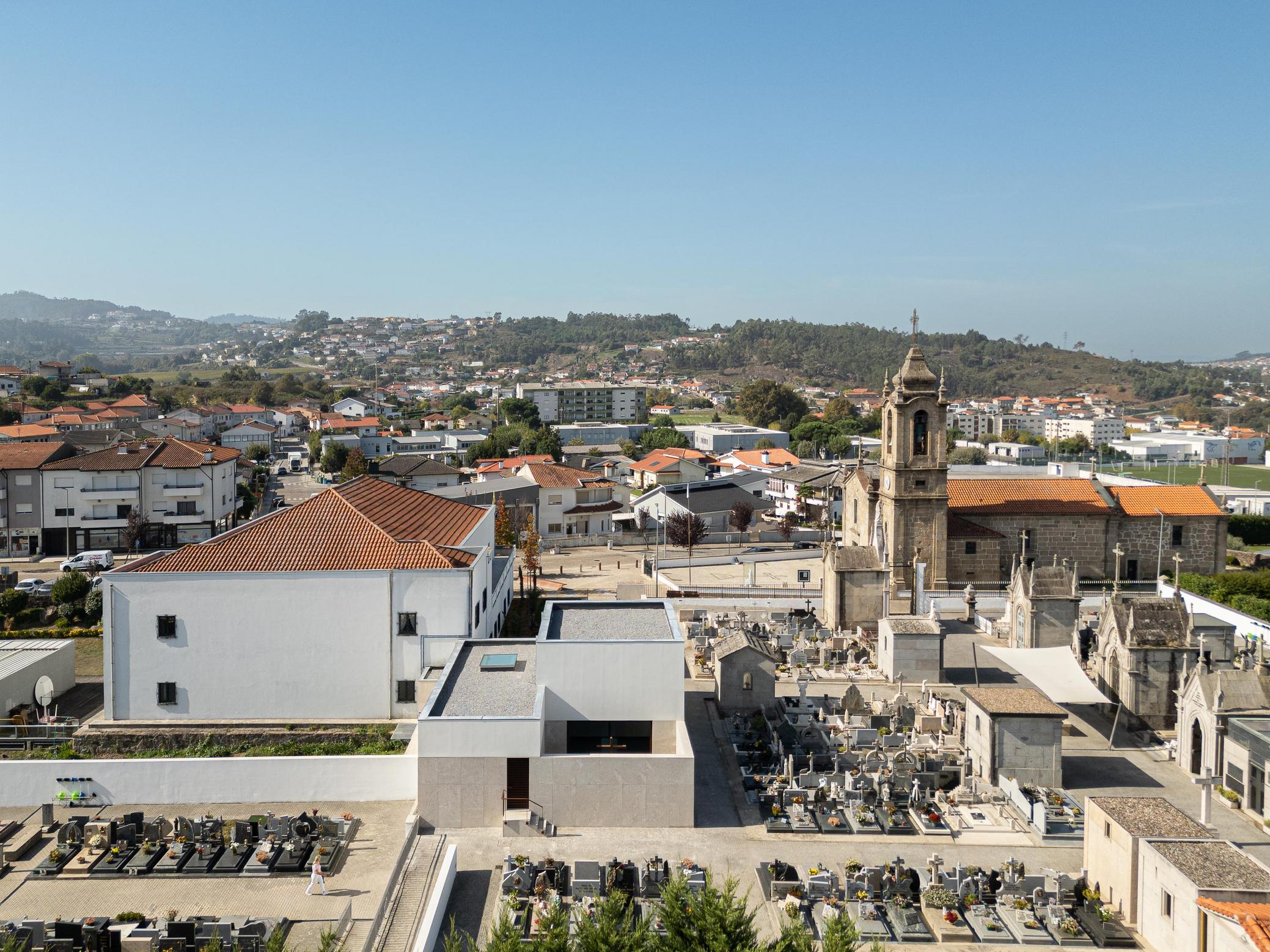 Exterior: Vista aérea da casa mortuária integrada no cemitério e na paisagem urbana. — Casa Mortuária São Martinho do Campo arquitetura Multiprojectus em Santo Tirso