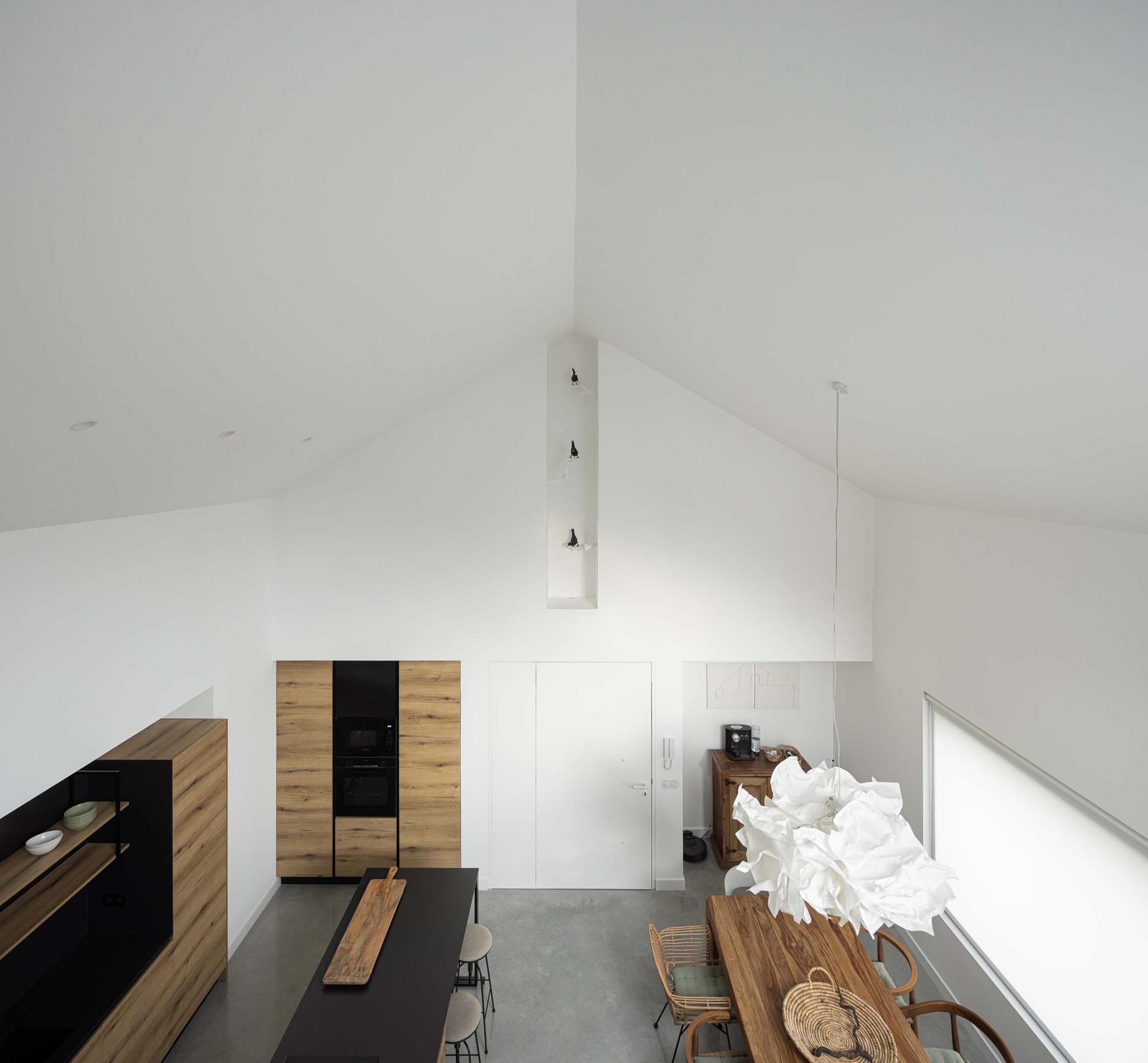 Sala de jantar: Vista de cima da sala de jantar com cozinha, mesa de madeira e cadeiras. — CASINHA DA MELROEIRA arquitetura Filipe Saraiva Arquitectos em Ourém