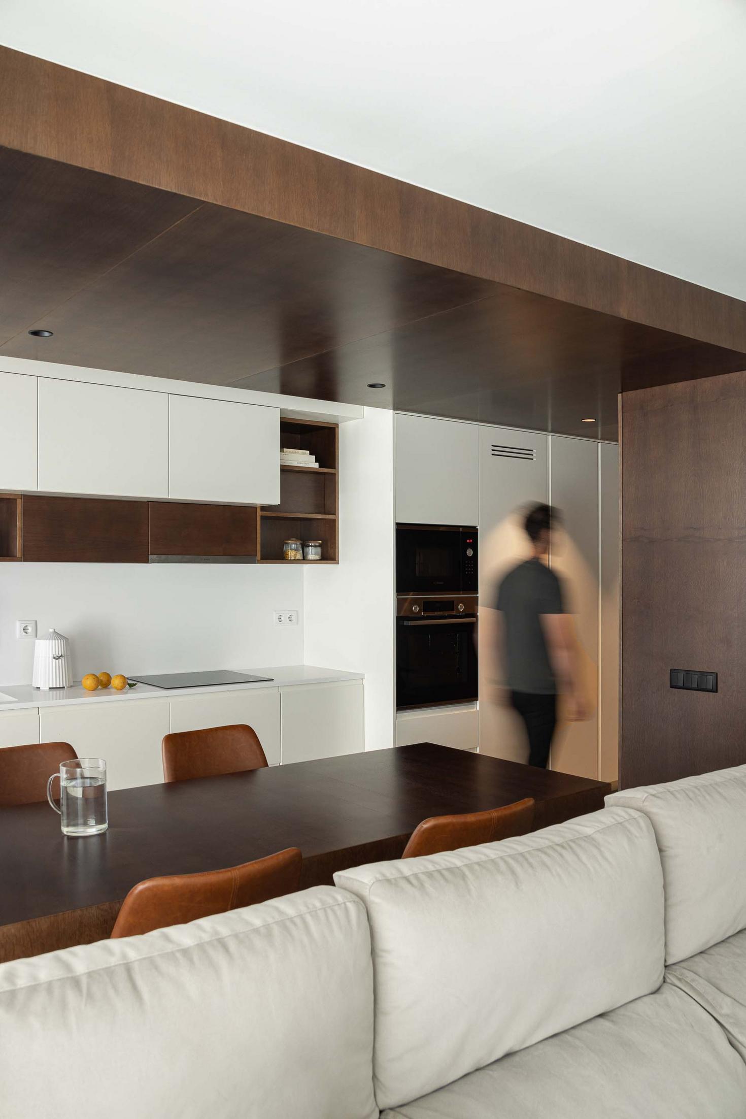 Cozinha/Sala de estar: Sofá branco. Mesa de madeira escura com cadeiras em pele castanha. Pavimento em madeira e cimento. — APARTAMENTO FP arquitetura ArquitectosRT em Braga