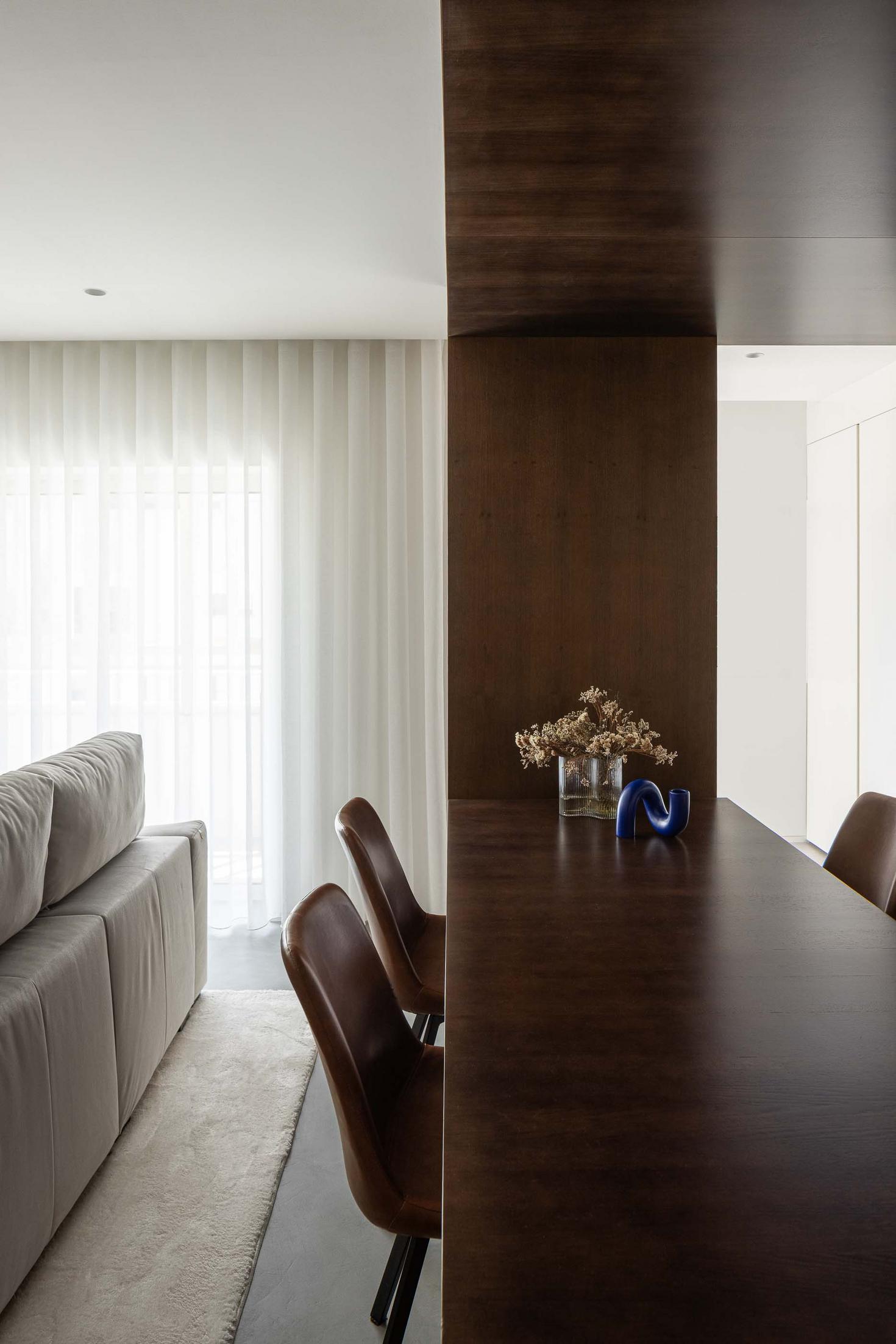 Sala de estar/Sala de jantar: Sofá branco com cortinas brancas. Mesa de madeira escura com cadeiras em pele castanha. — APARTAMENTO FP arquitetura ArquitectosRT em Braga