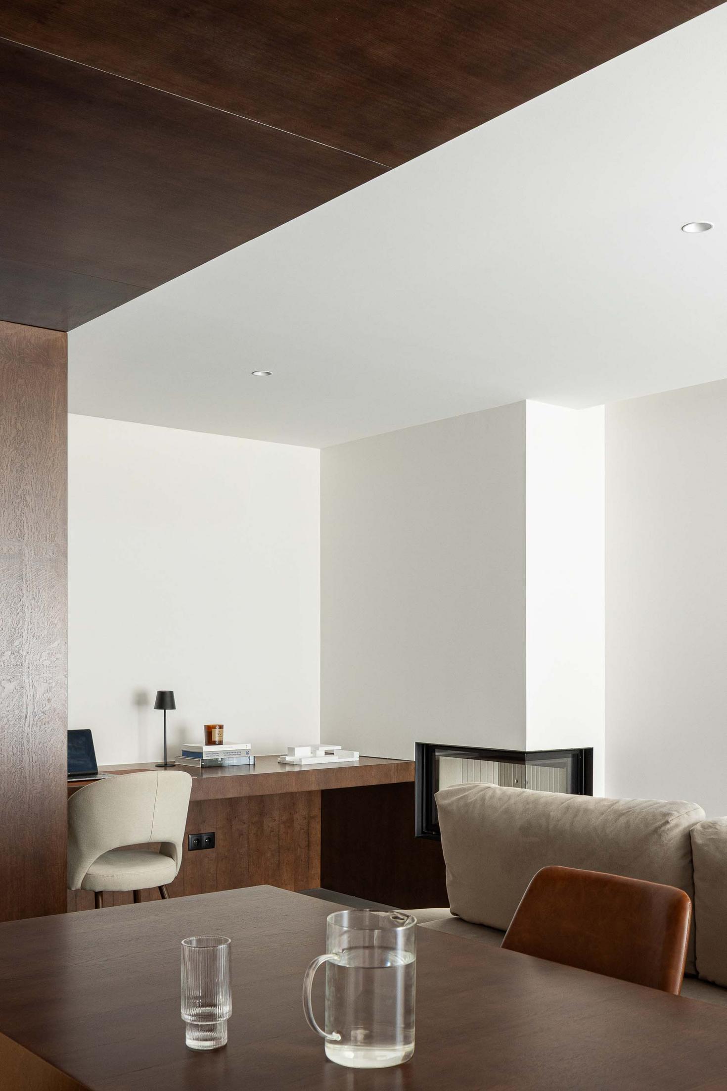 Sala de estar/Escritório: Lareira moderna. Secretária em madeira. Mesa de madeira escura com cadeiras em pele castanha. — APARTAMENTO FP arquitetura ArquitectosRT em Braga