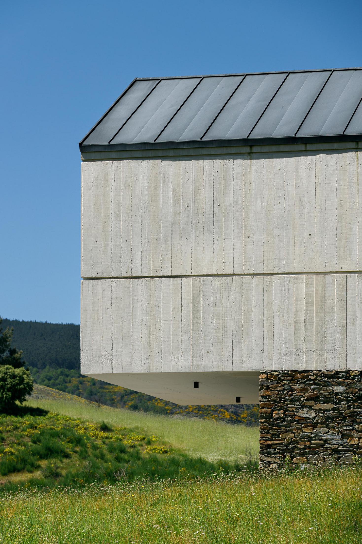 Exterior: Detalhe da fachada em betão aparente e pedra, com janela embutida. — TerraSense Mountain Charm Retreat arquitetura DRK Atelier em Guarda