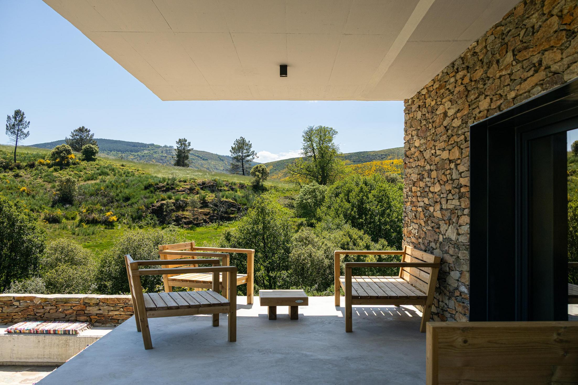 Exterior: Alpendre com cadeiras de madeira e vista para a paisagem natural. — TerraSense Mountain Charm Retreat arquitetura DRK Atelier em Guarda