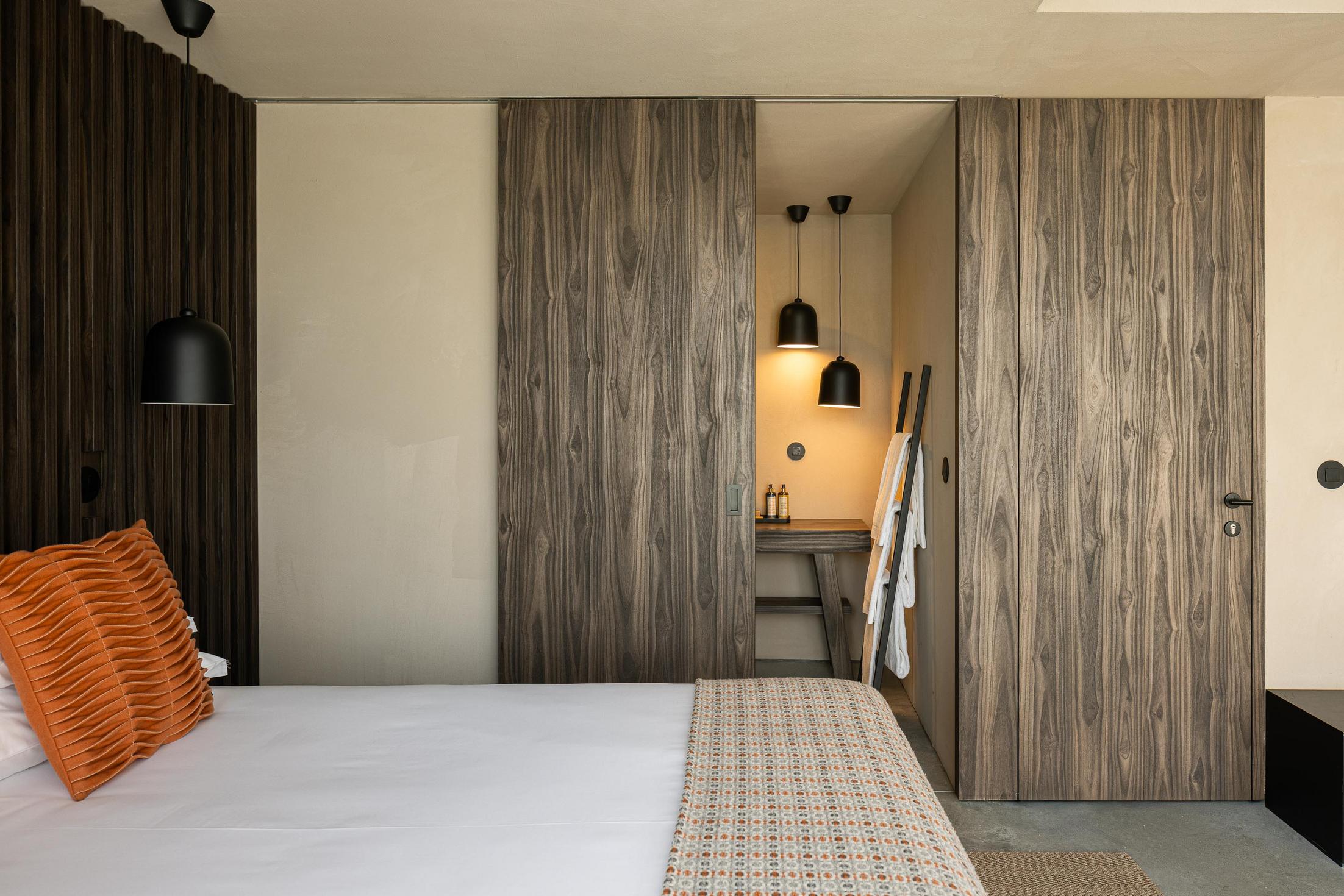 Quarto: Cama de casal com roupeiro embutido e casa de banho privativa. — TerraSense Mountain Charm Retreat arquitetura DRK Atelier em Guarda