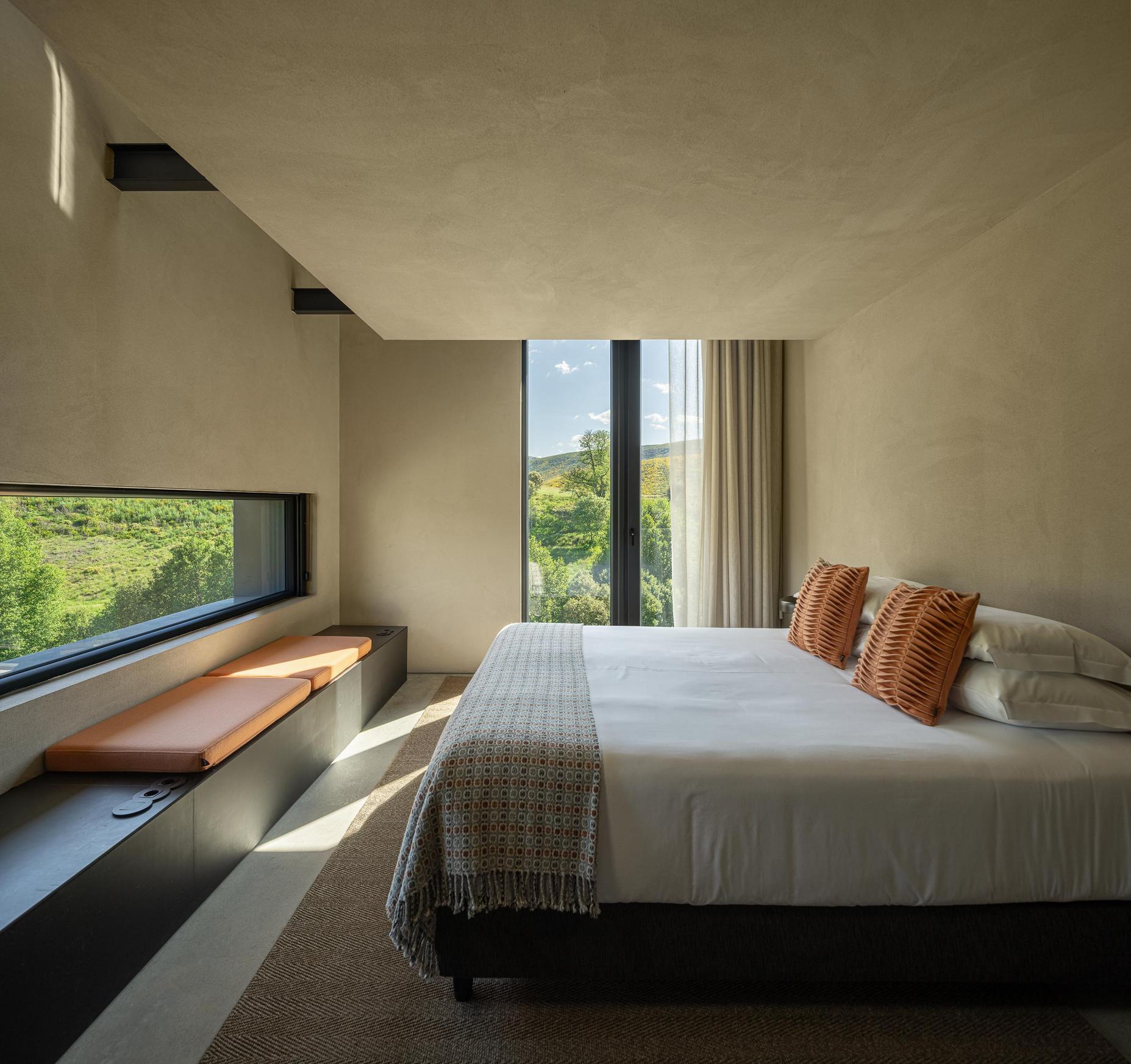 Quarto: Cama de casal com janela horizontal e vista para a paisagem. — TerraSense Mountain Charm Retreat arquitetura DRK Atelier em Guarda