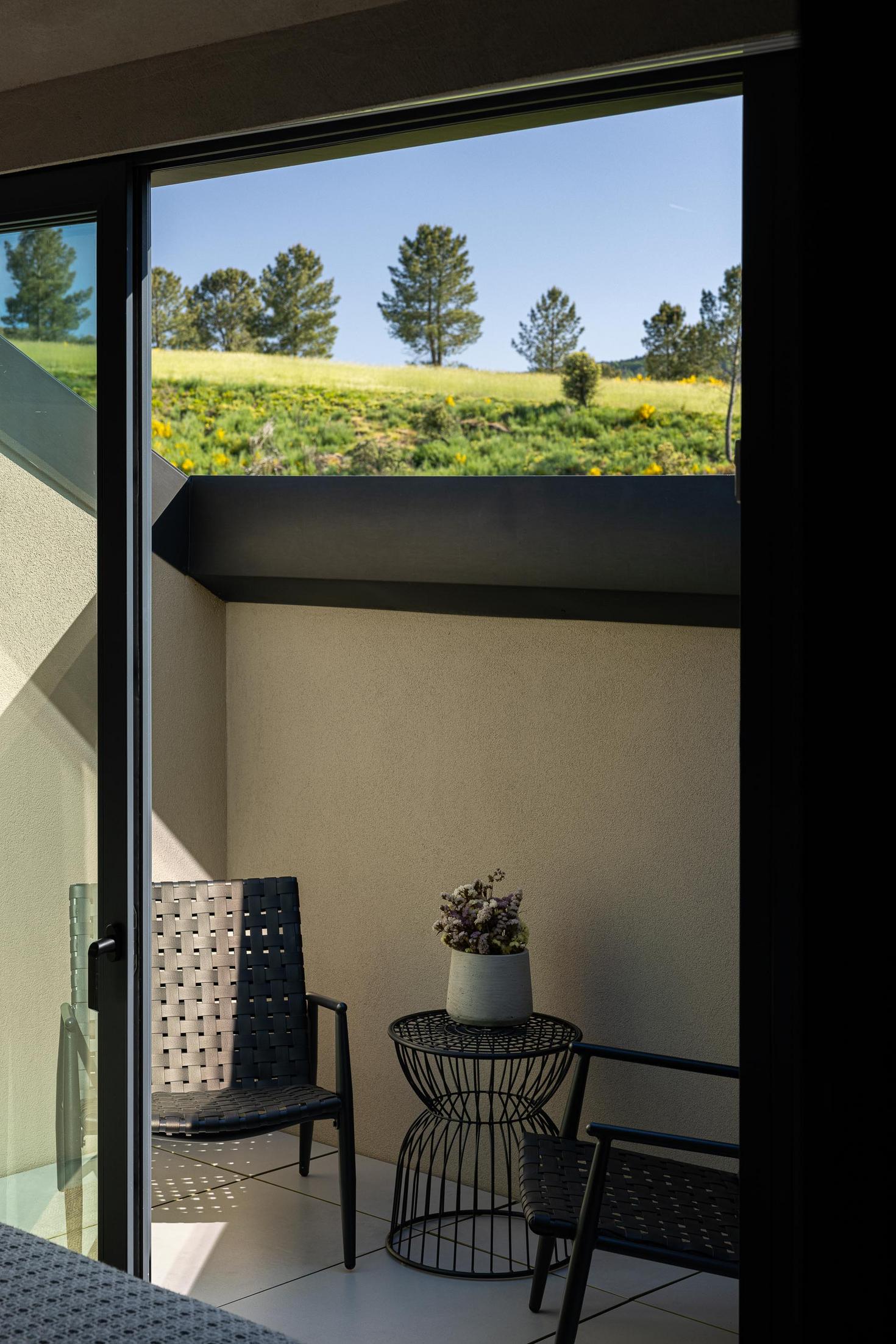 Quarto: Varanda com cadeiras de vime e vista para a natureza. — TerraSense Mountain Charm Retreat arquitetura DRK Atelier em Guarda