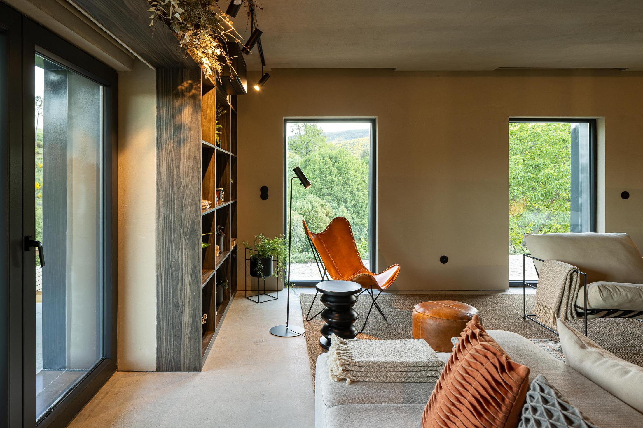 Sala de estar: Sofás claros, lareira moderna e balcão em granito ao fundo. — TerraSense Mountain Charm Retreat arquitetura DRK Atelier em Guarda