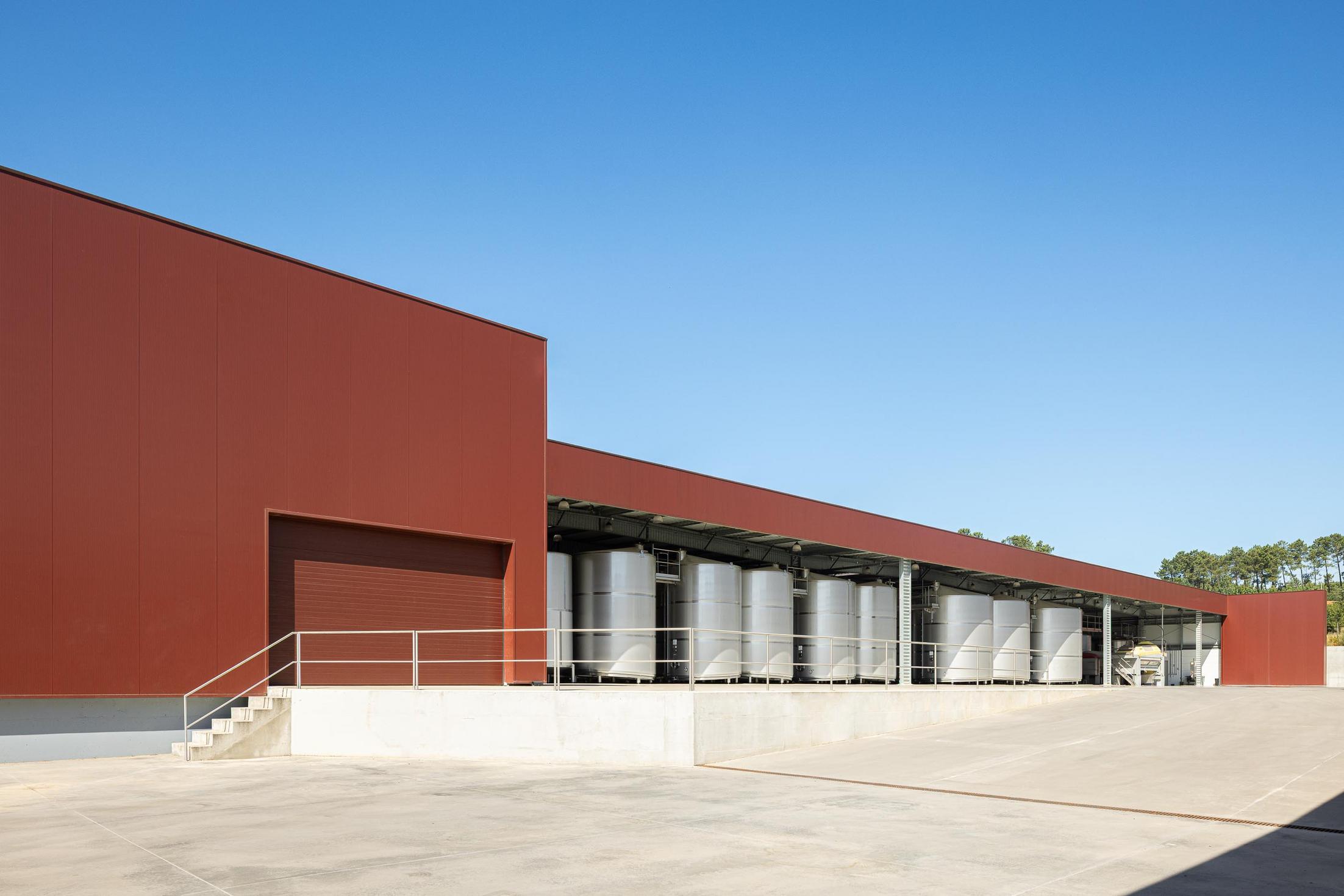 Exterior: Edifício industrial com revestimento cor de vinho e zona de tanques de inox. — Adega Vinhos Borges arquitetura Em Paralelo em Vila Real