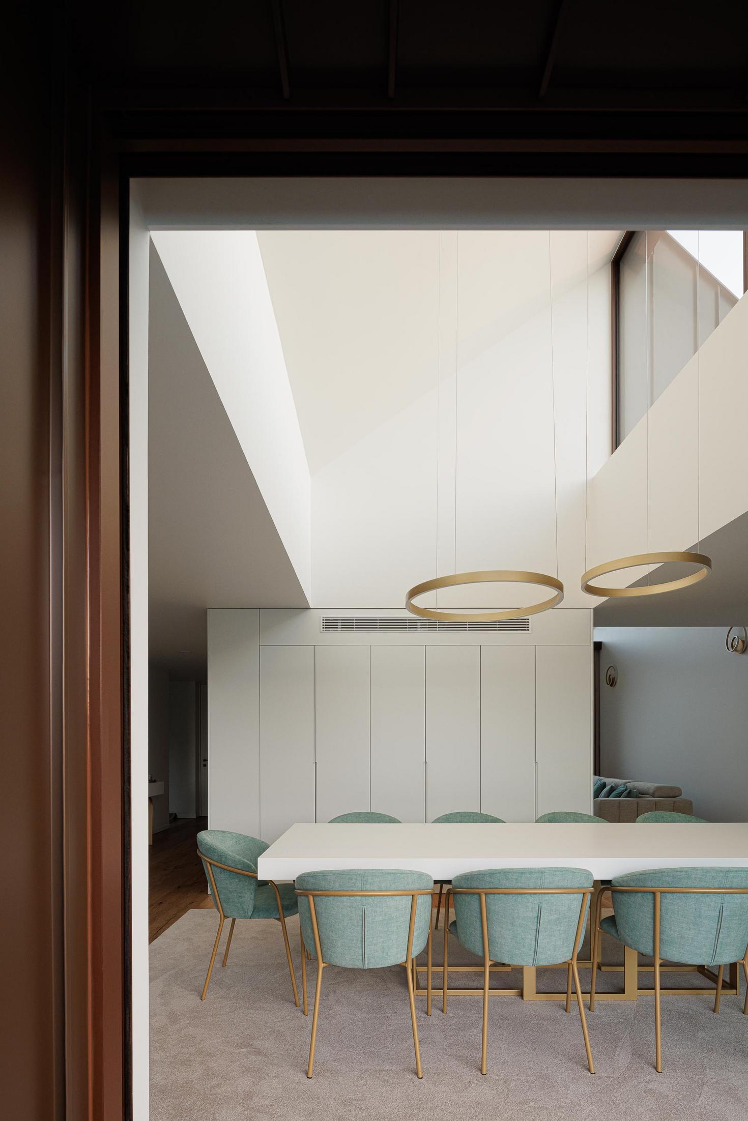 Sala de jantar: Vista da sala de jantar com mesa, cadeiras, alcatifa e armários brancos. — House SM arquitetura Mário Alves Arquitecto em Ílhavo