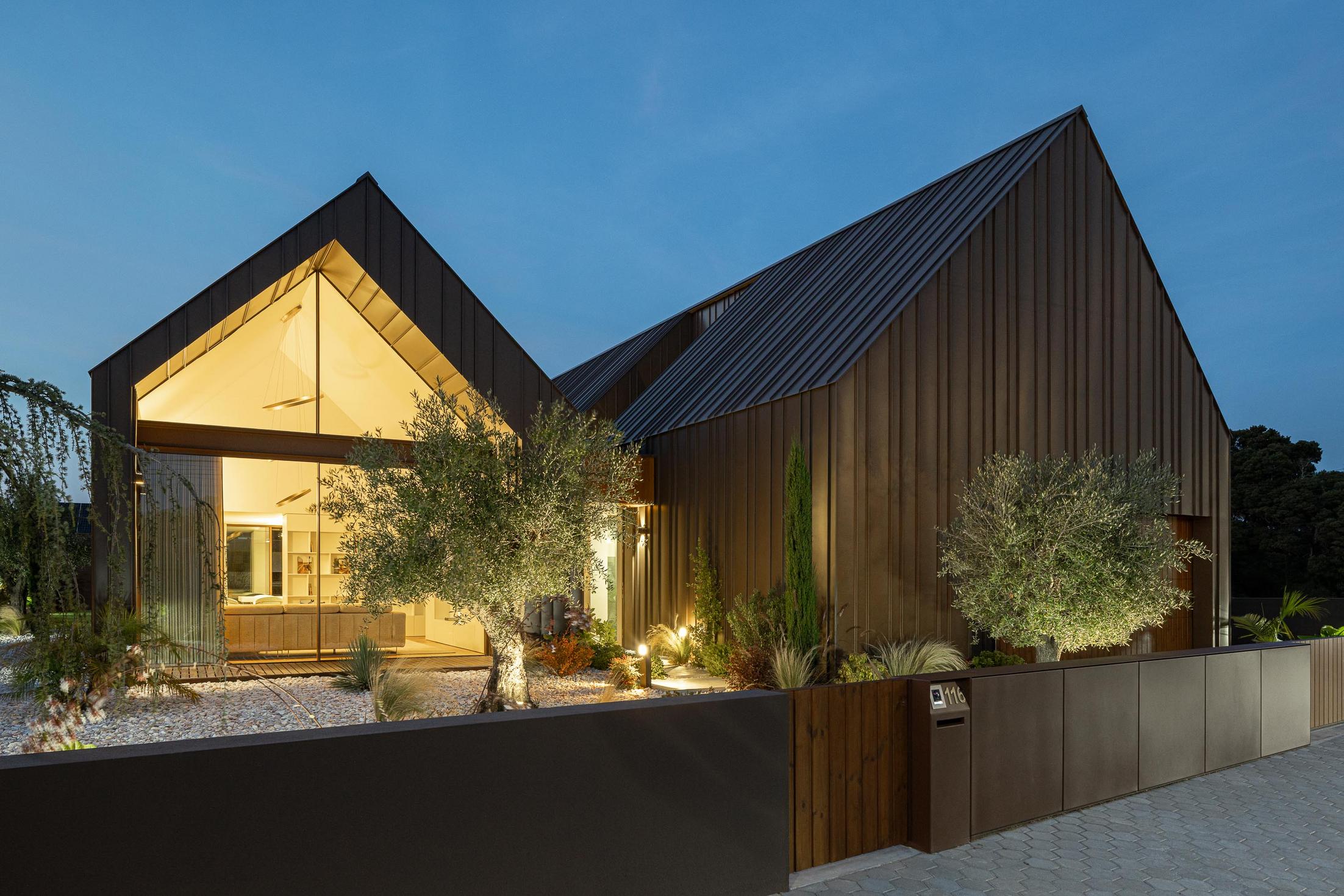 Exterior: Vista geral da casa ao entardecer com jardim e iluminação exterior. — House SM arquitetura Mário Alves Arquitecto em Ílhavo
